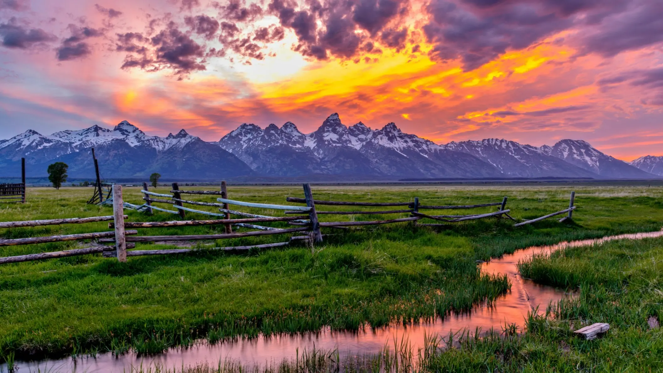 États-Unis Wyoming Parc national du Grand Teton Un coucher de soleil printanier coloré dans la chaîne de Teton, vu depuis un vieux ranch abandonné dans le quartier historique de Mormon Row, dans le parc national de Grand Teton, Wyoming, États-Unis.