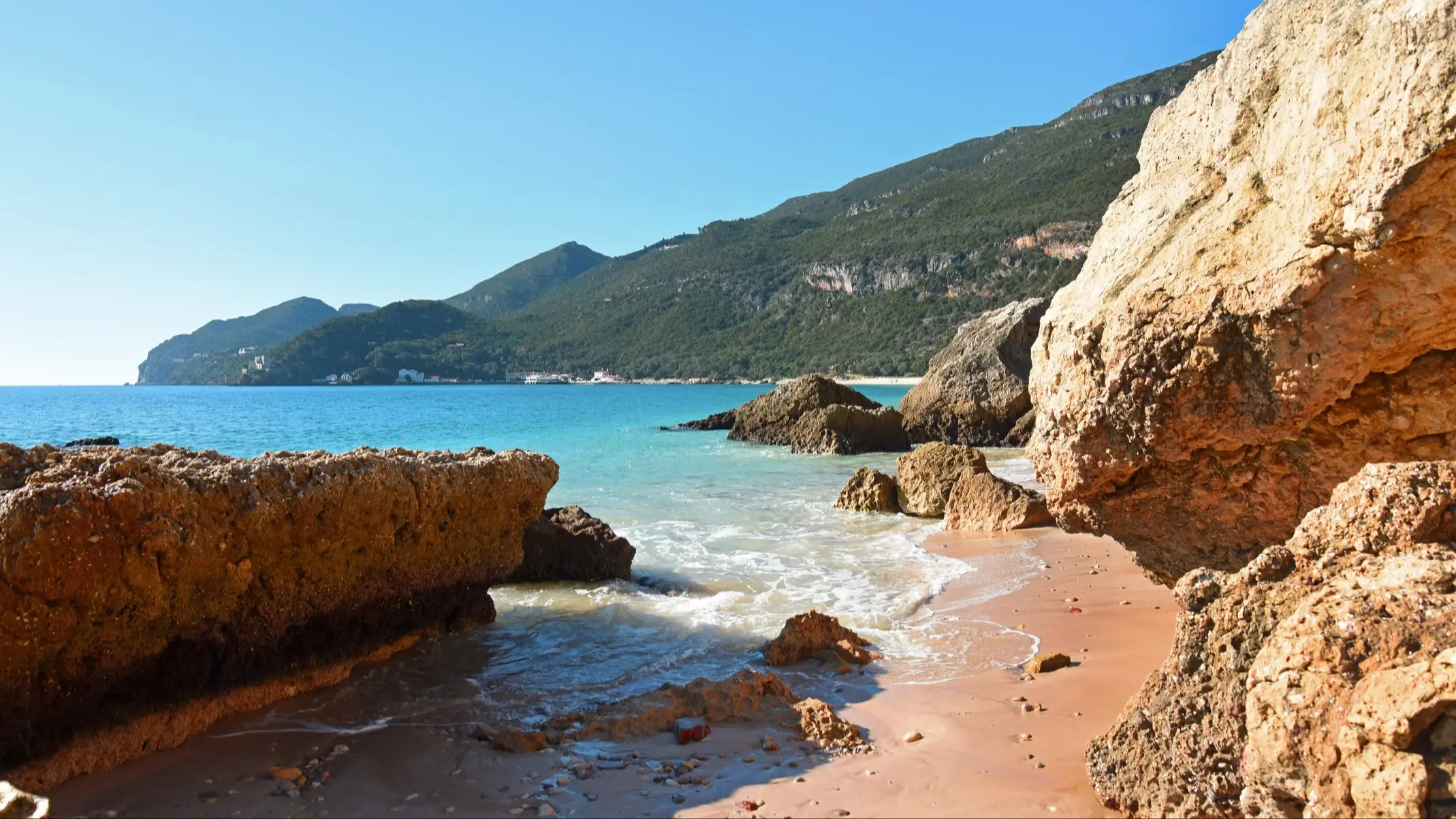 Portinho da Arrábida, Setúbal, Portugal Felsen in der Bucht von Portinho da Arrábida, Setúbal, Portugal mit Blick auf die Berge im Hintergrund und bei herrlichem Sonnenschein.