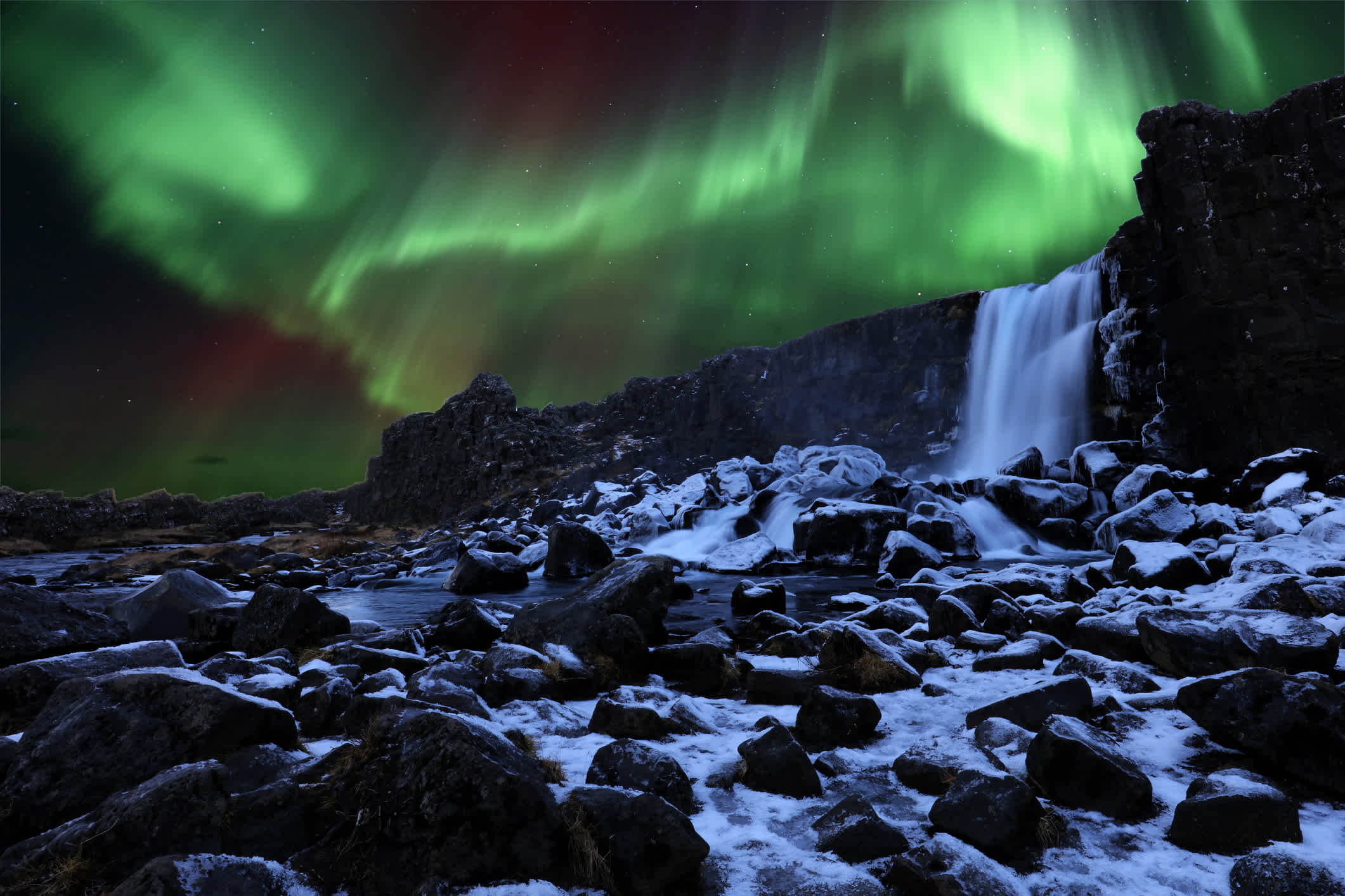 Polarlichter beim Oxararfoss Wasserfall in Thingvellir Nationalpark, Island.