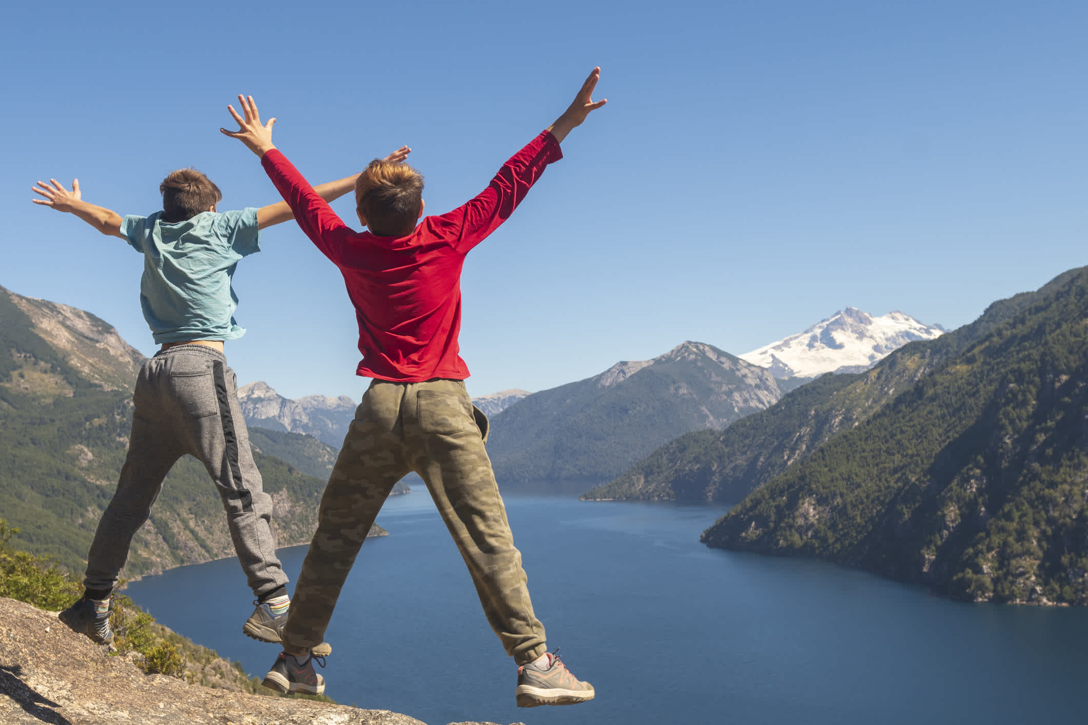 Brüder springen vor Glück vor einer solchen Landschaft in der Umgebung von San Carlos de Bariloche