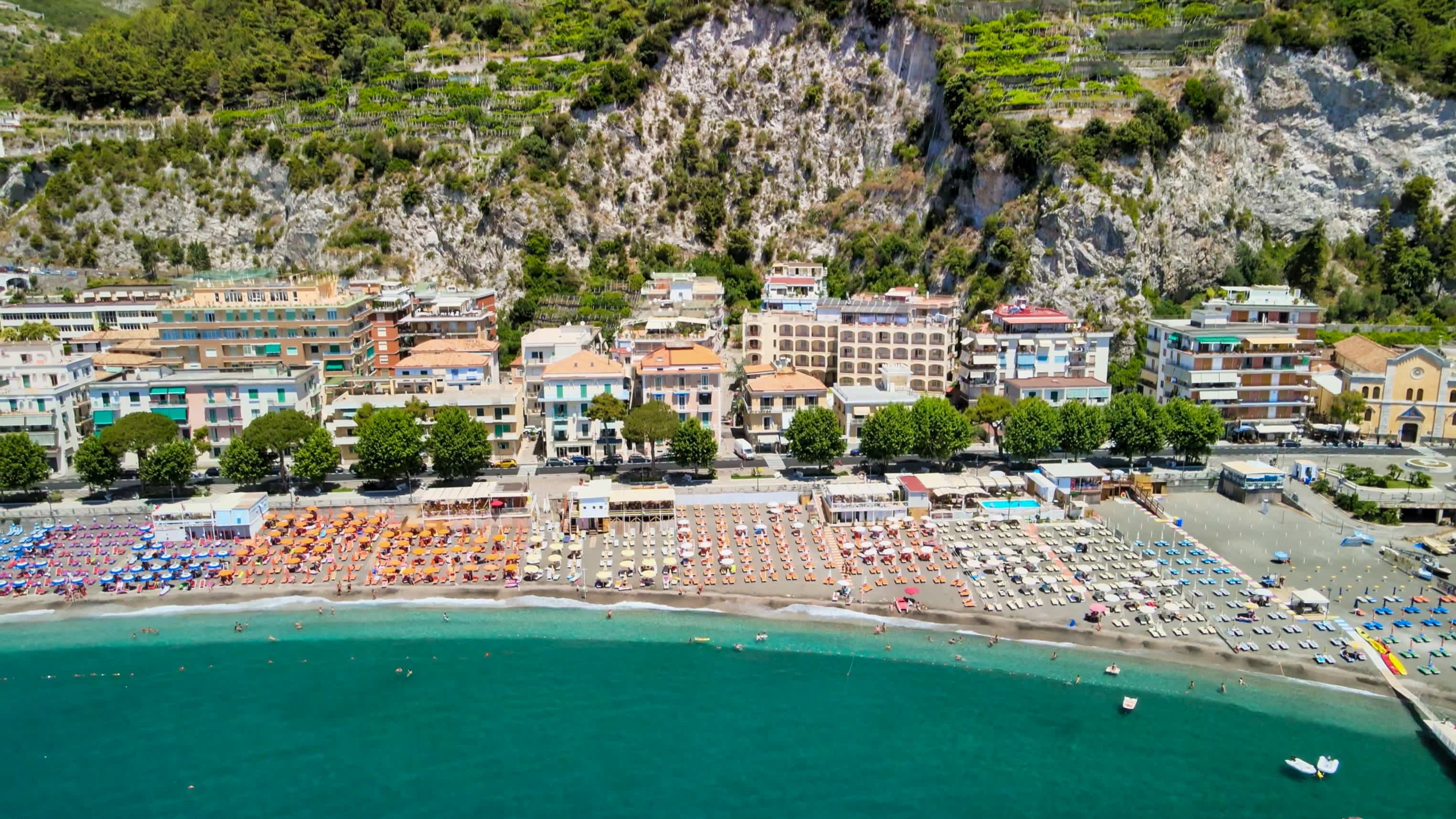 Vue aérienne de Maiori Beach avec ses parasols colorés et sa longue plage, sur la côte Amalfitaine, en Italie.