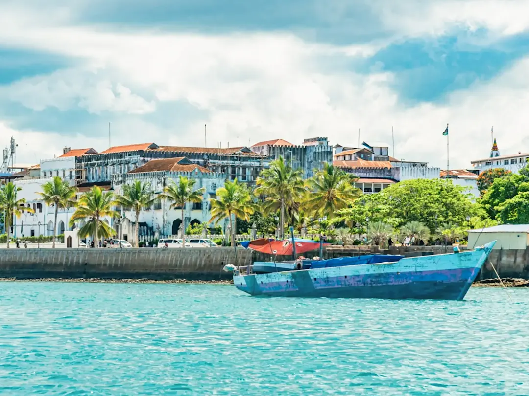 Historische Gebäude und tropische Palmen in Stone Town, Sansibar, Tansania.