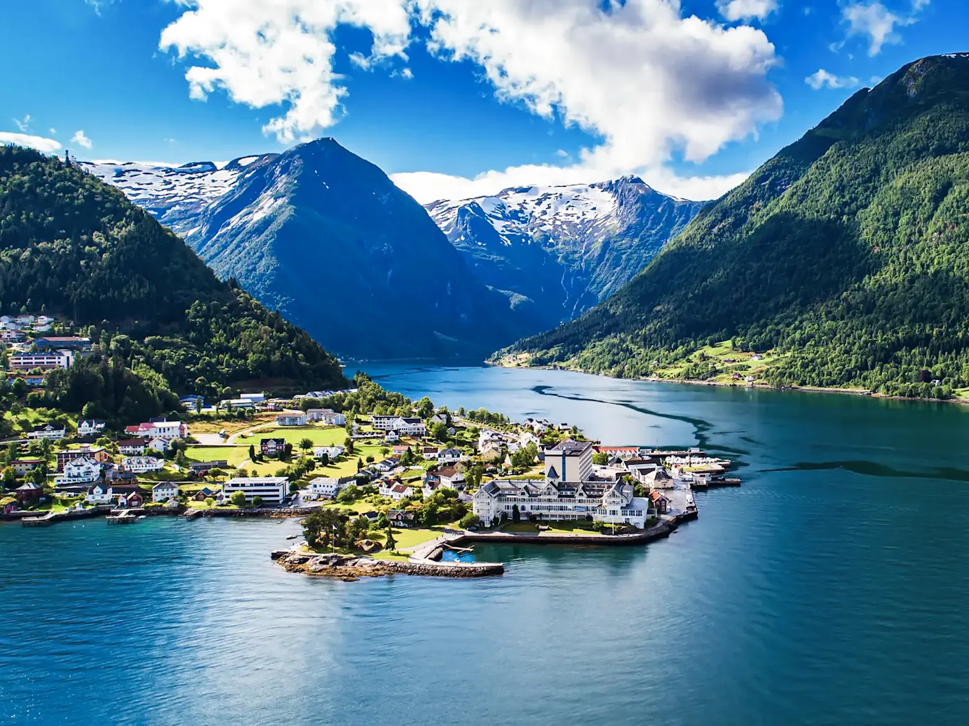 Une petite ville sur un fjord tranquille entourée de montagnes boisées, Balestrand, Norvège.