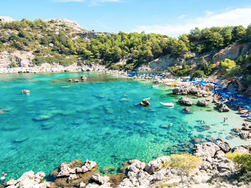 Baie cristalline avec rochers et plage de sable. Plage Anthony Quinn, Rhodes, Dodécanèse, Grèce.