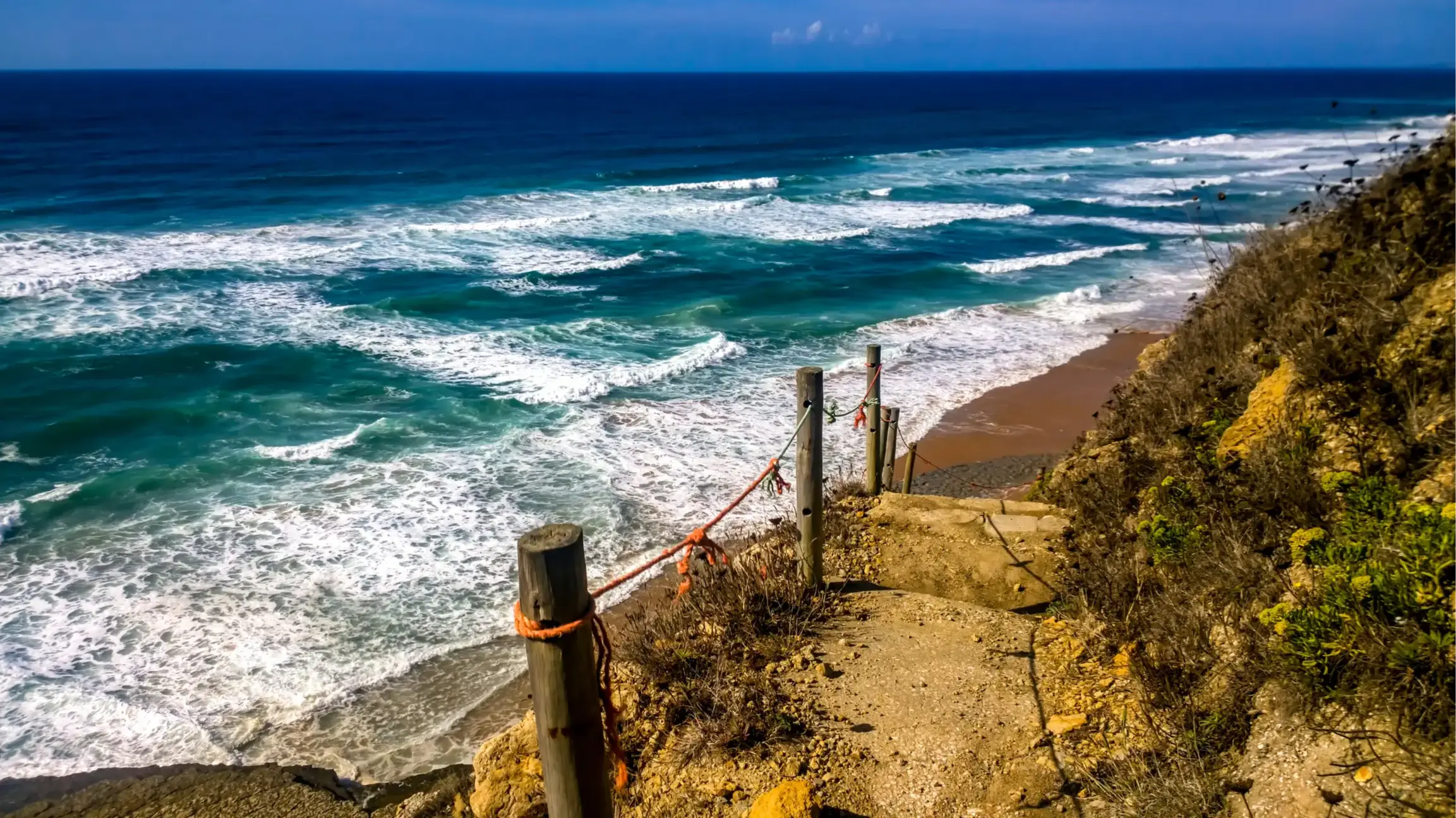 Praia Da Aguda, Portugal Der Strand Praia Da Aguda, Portugal mit Blick auf einen gesicherten Weg, der an der Klippe entlang führt und mit Aussicht auf das weite blaue Meer.