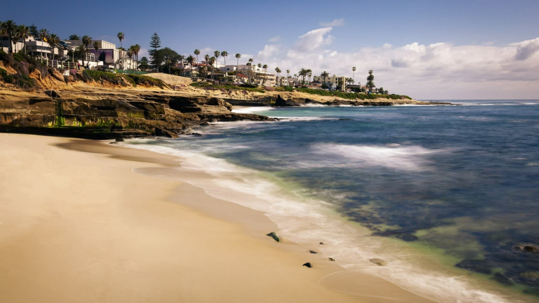 Der Strand La Jolla Shores, La Jolla, Kalifornien, USA bei herrlichem Sonnenschein und mit Blick auf den goldenen Sand, das Riff sowie Villen entlang der Küste.