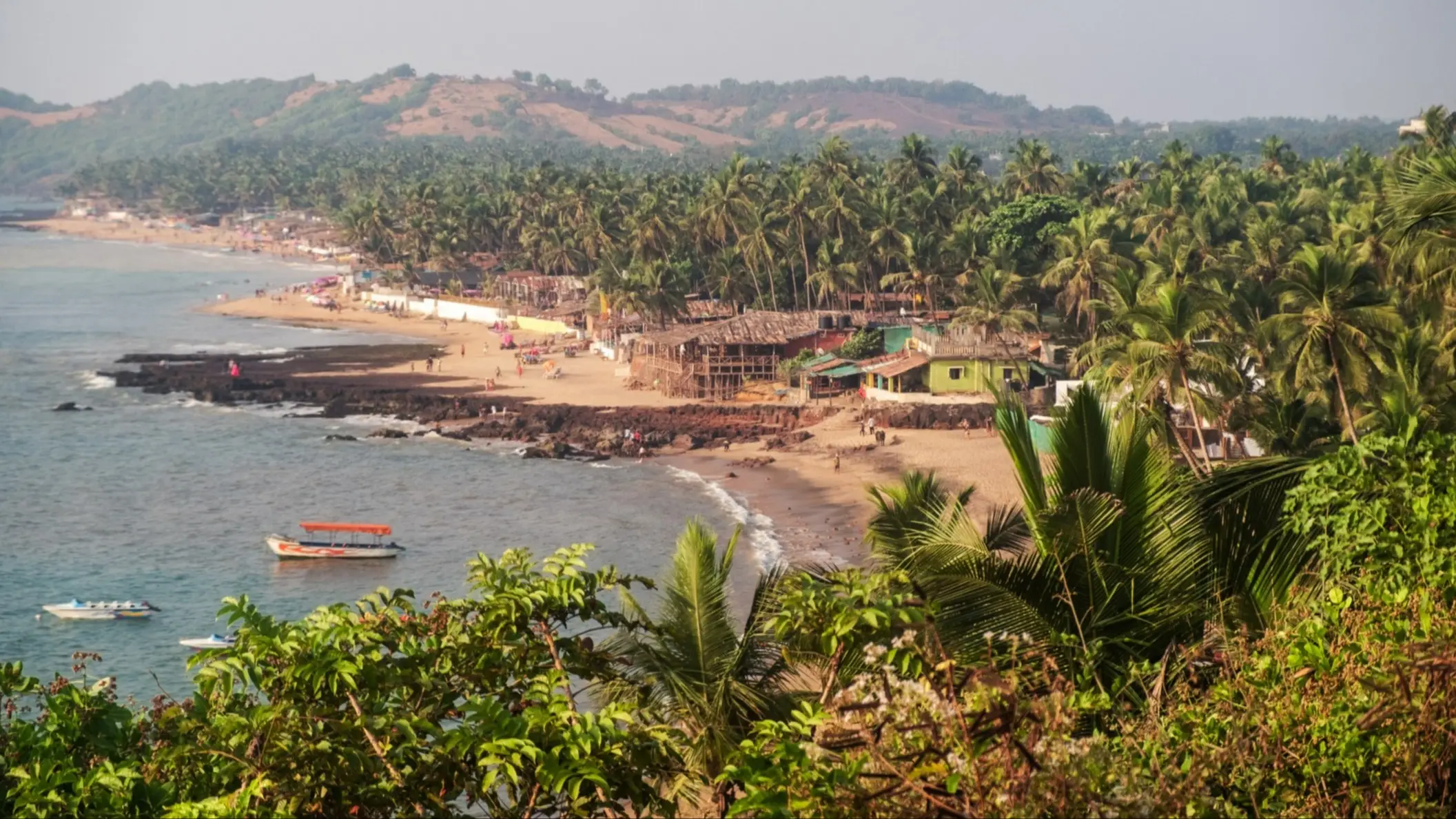 Anjuna Beach, Goa, Indien Naturbelassener Strand Anjuna Beach, Goa, Indien mit dichtem Dschungel sowie Aussicht auf die bergige Landschaft.