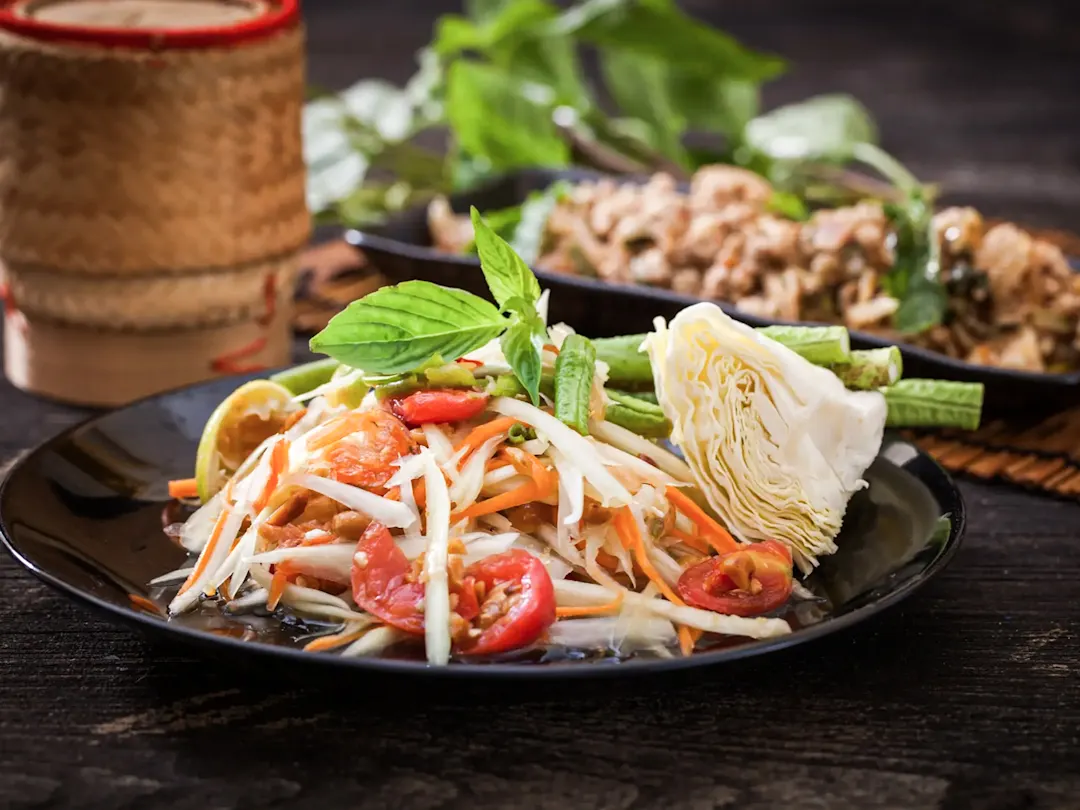 Traditionelles thailändisches Gericht, Som Tam, scharfer Papayasalat mit Limette und Erdnüssen.