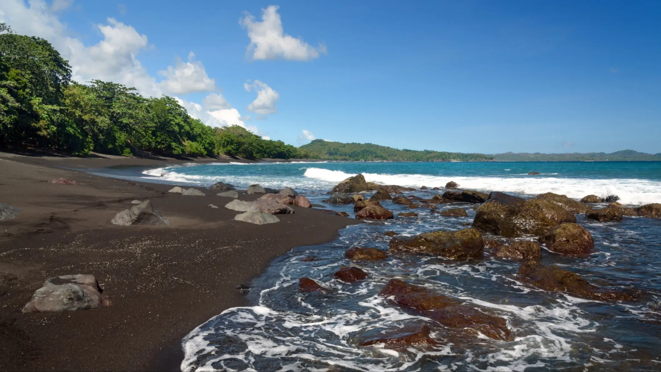 Vue sur la plage volcanique de sable noir.