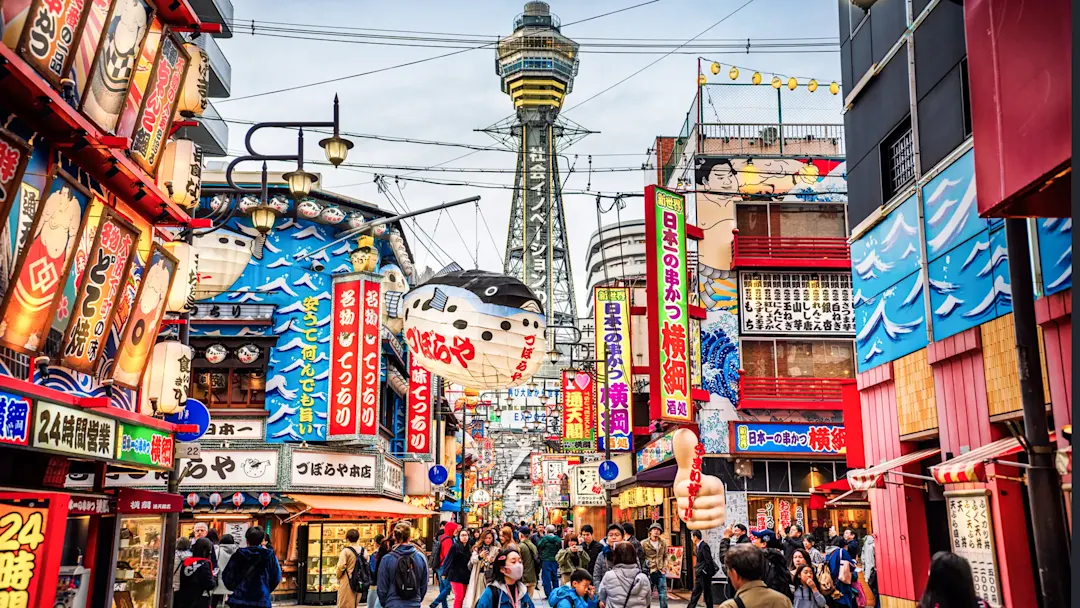 Bunte Straßen mit Tsutenkaku-Turm im Hintergrund, Osaka, Kansai, Japan.