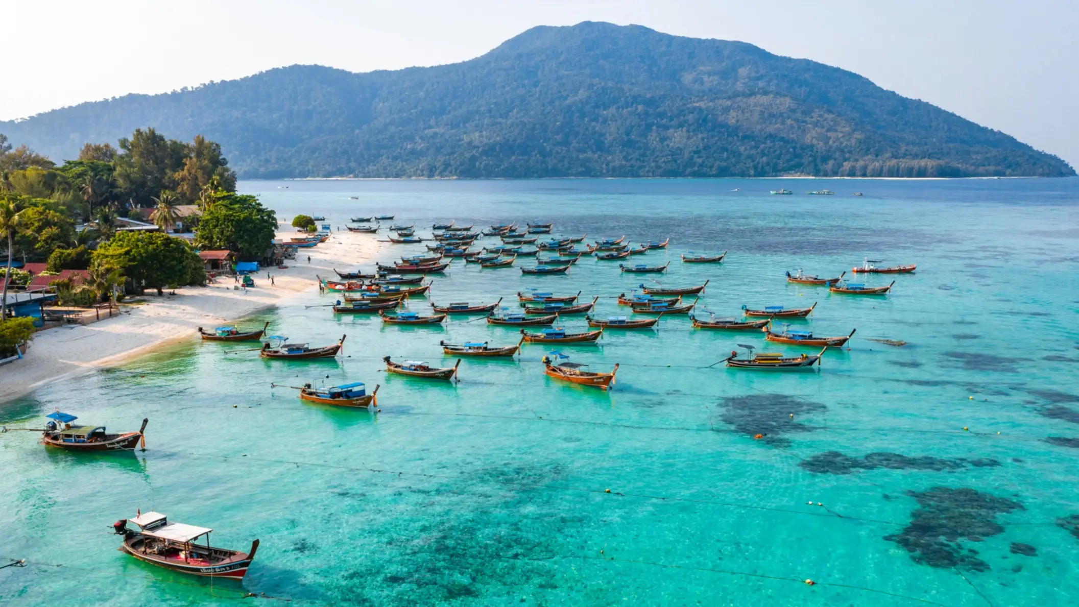 Luftaufnahme von Sunrise Beach mit Longtail-Booten in Koh Lipe, Thailand.