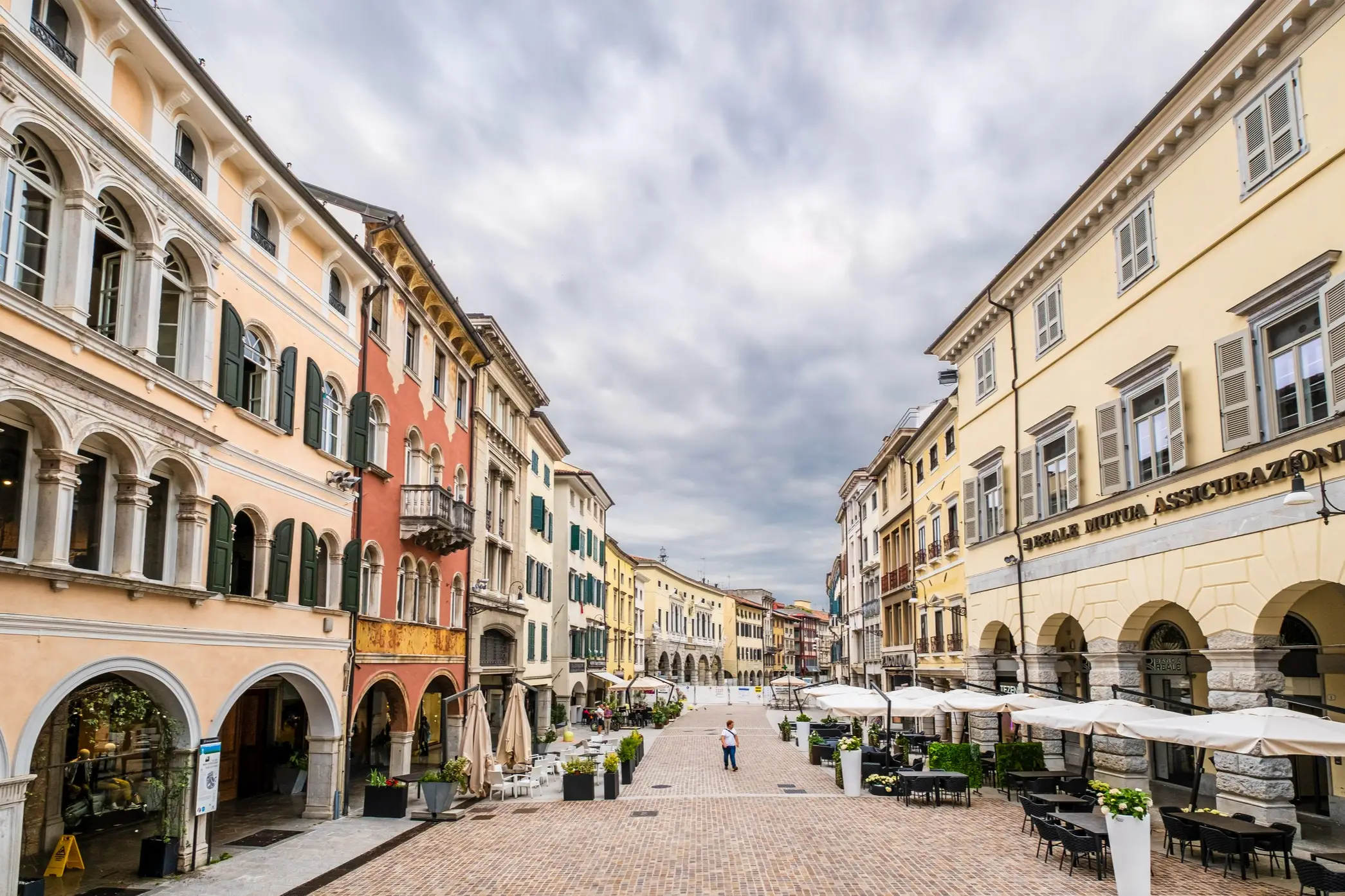 Rue historique du centre-ville d'Udine avec des arcades et des bâtiments anciens