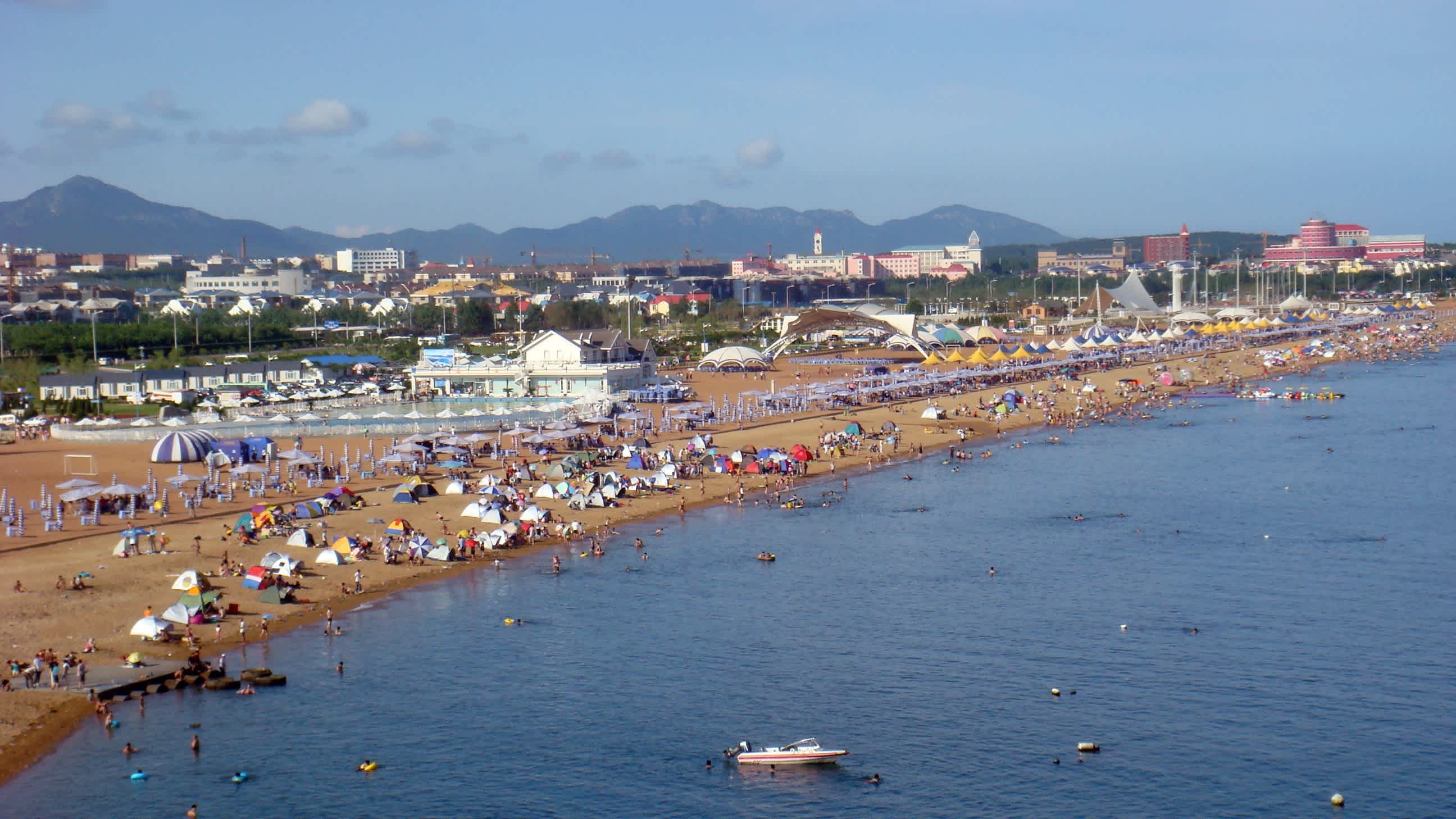 Blick auf den gefüllten Stadt-Strand in Dalian, China bei schönem Wetter.