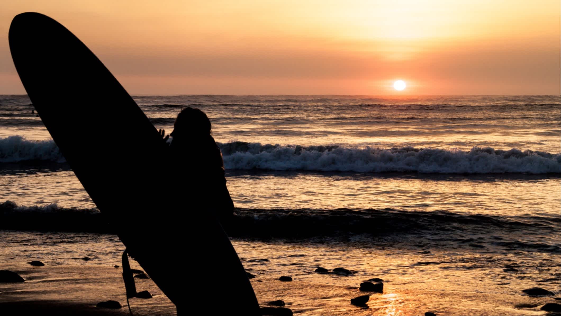 Surfeur au coucher du soleil, plage de Huanchaco, Pérou