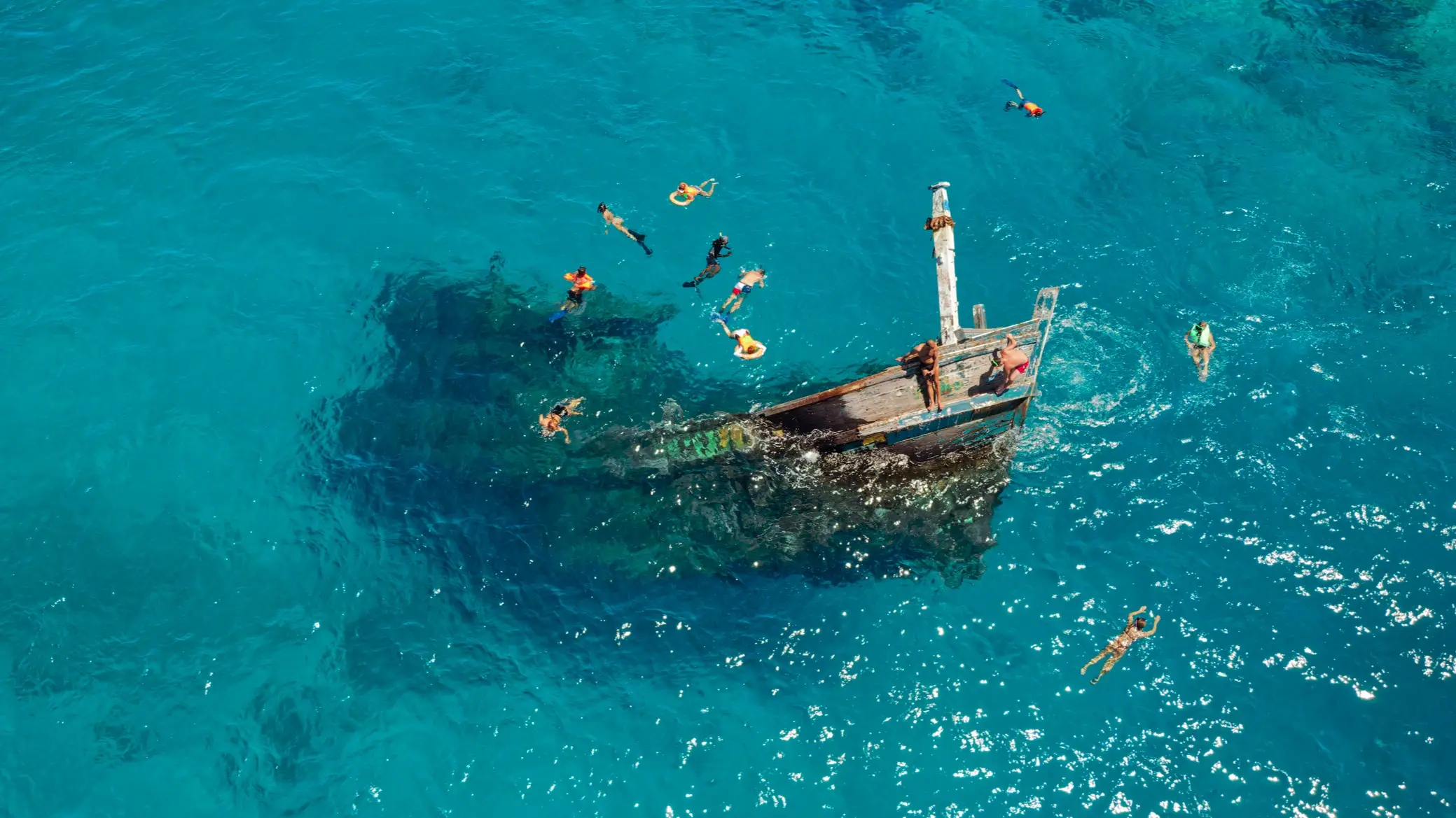 Malediven, Keyodhoo, Versunkenes Schiff Menschen tauchen und schnorcheln in der Nähe eines versunkenen Schiffs, das aus dem Wasser ragt