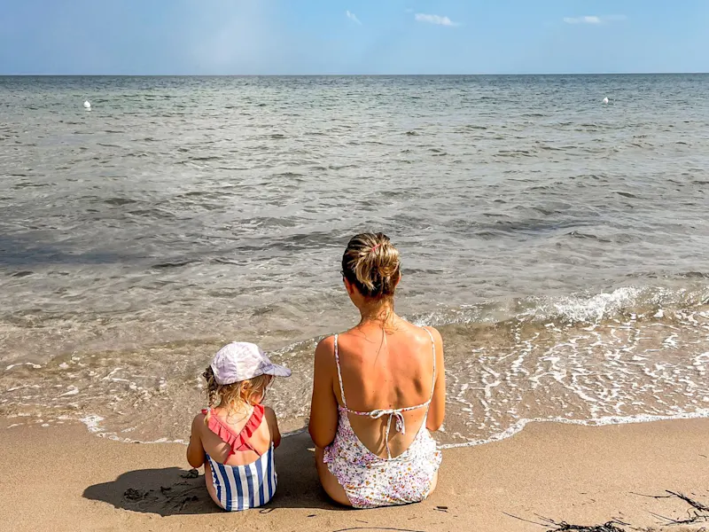 Anna-Lisa avec ses enfants à la plage, la mer en arrière-plan, en Italie.