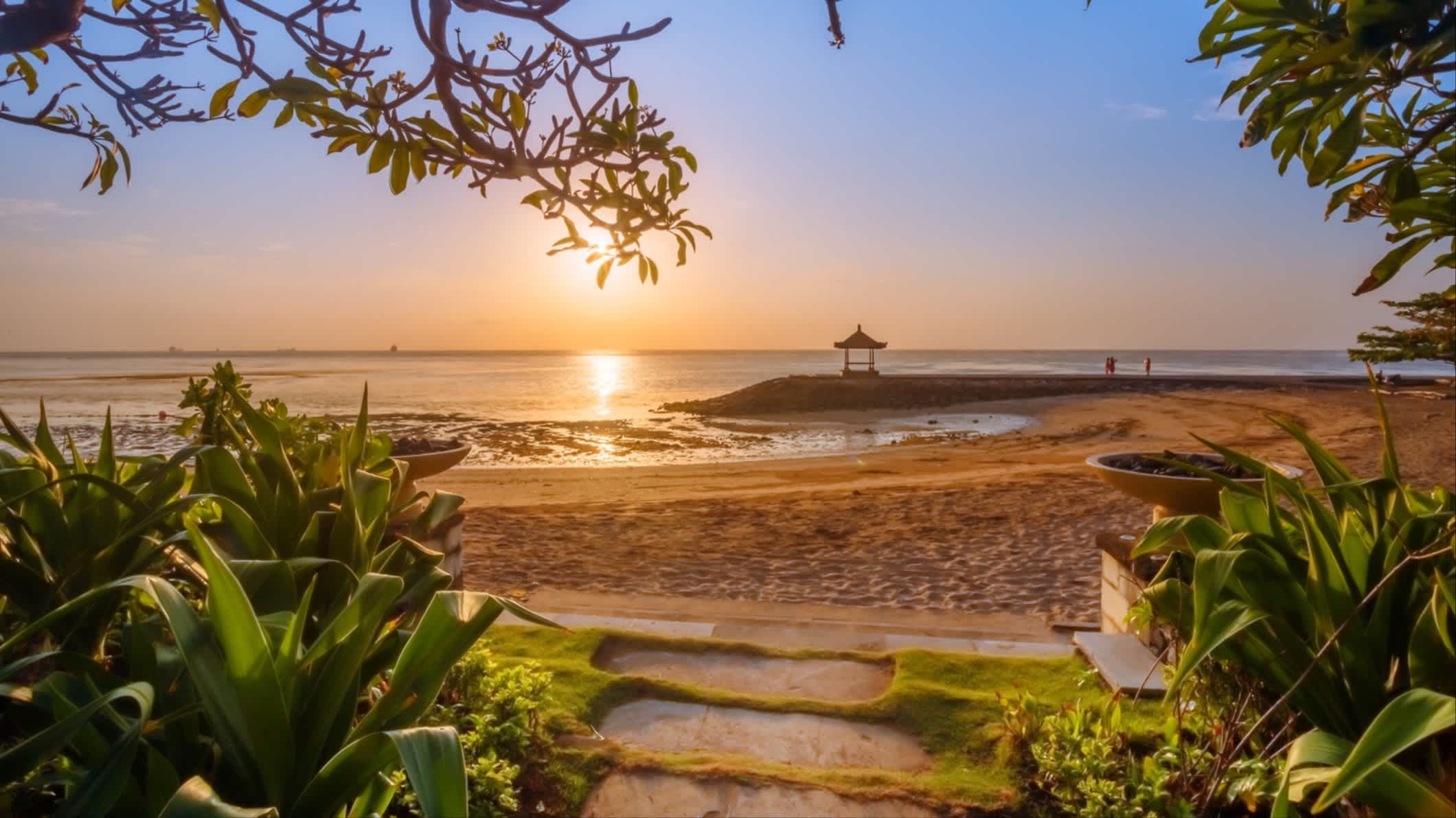 Aufnahme des Sonnenaufganges am Nusa Dua Beach auf Bali mit Pflanzen im Bild.