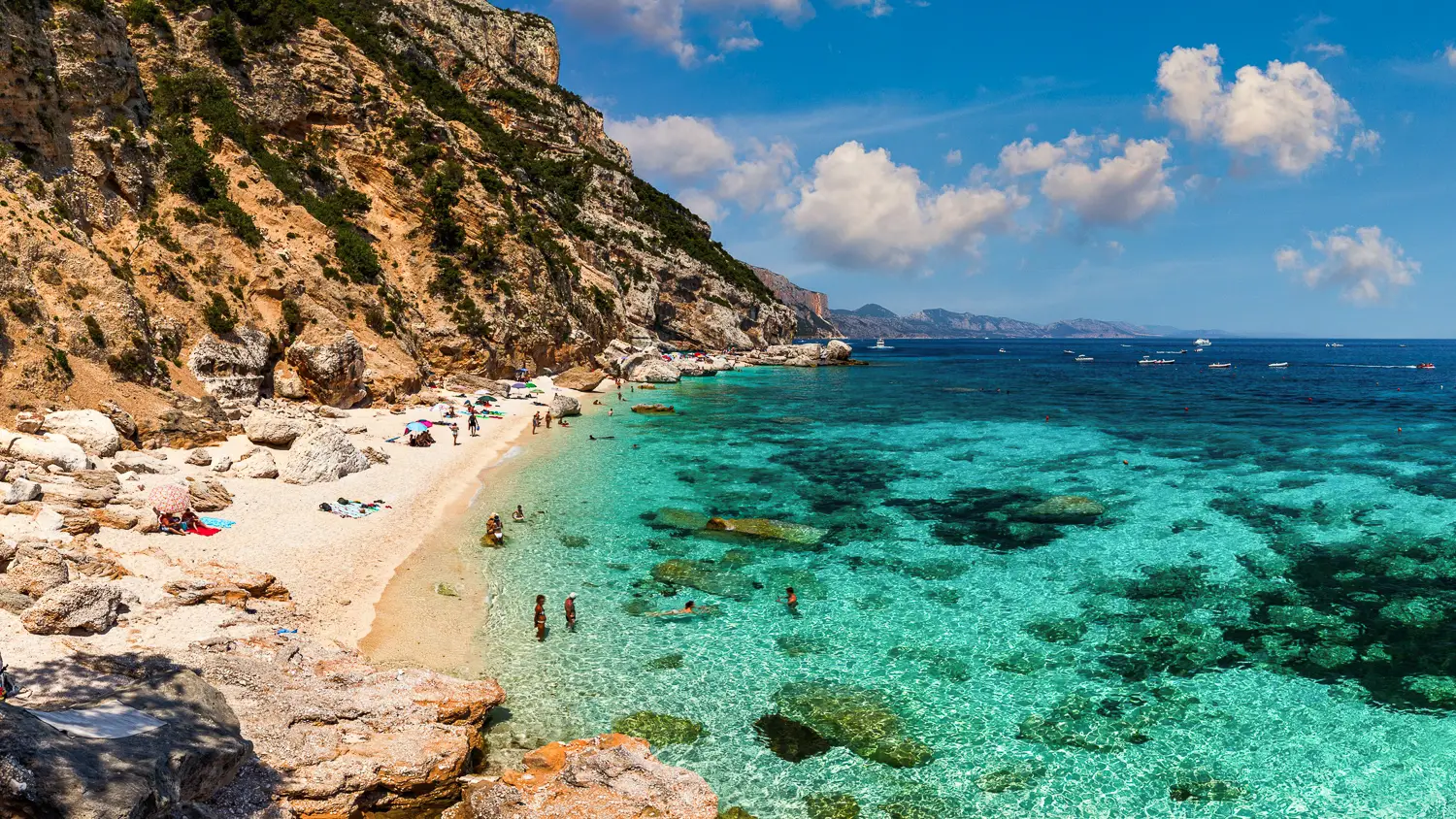Falaises qui entourent le sable blanc et l'eau cristalline de la plage de Cala Mariolu en Sardaigne