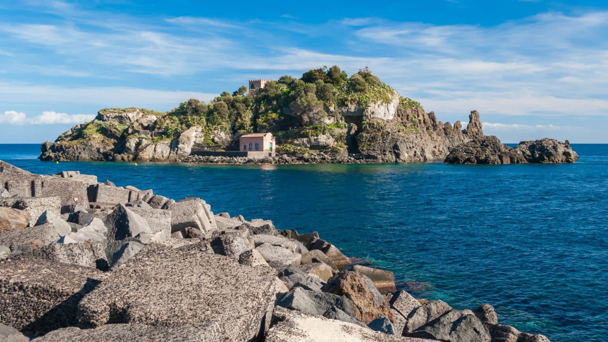 Die Insel Lachea in der " Riviera dei Ciclopi", Sizilien, Italien mit Blick auf die Felsen und ein Haus auf der Insel.