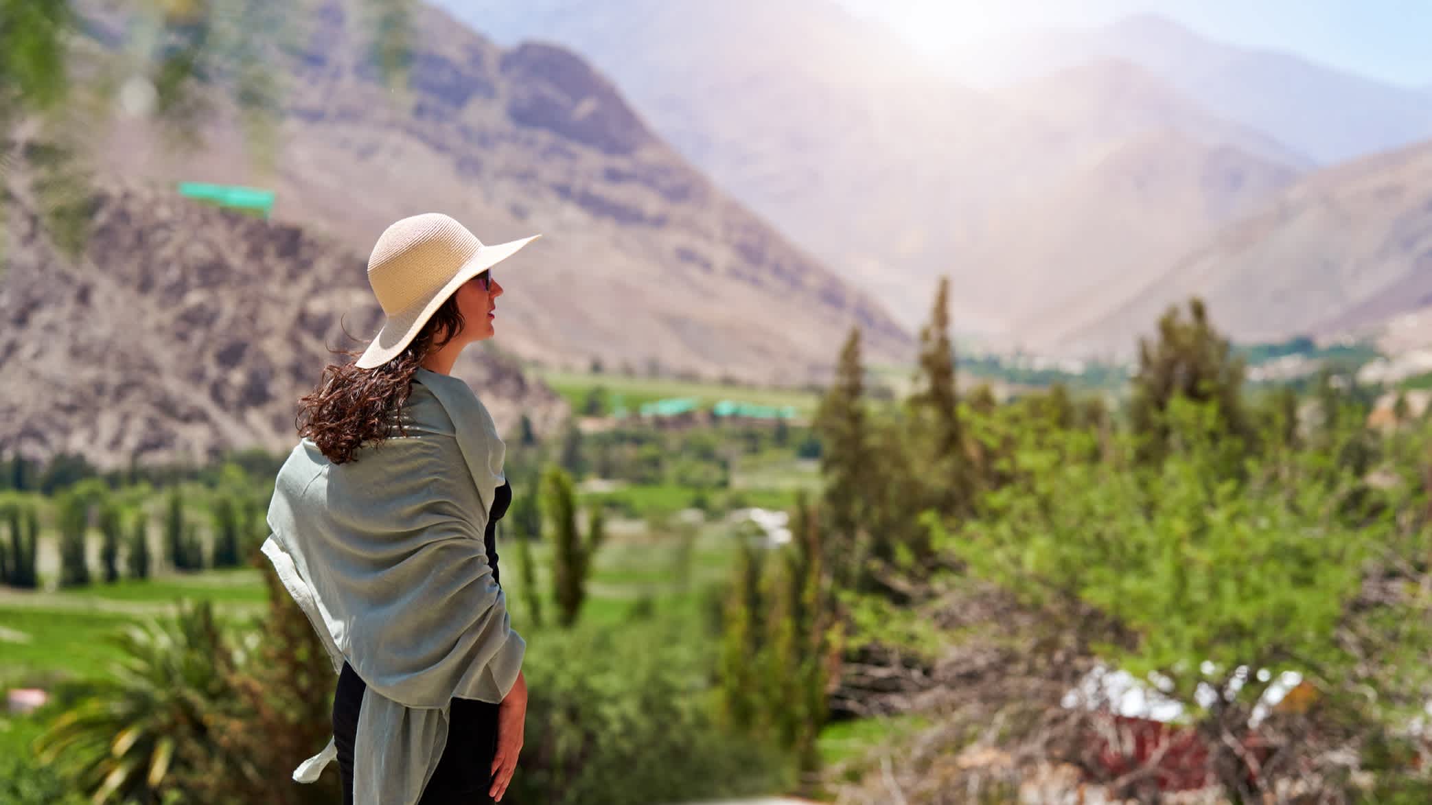 Latino-Touristin mit Blick auf die sonnige Landschaft in Paihuano, Valle del Elqui, Chile.

