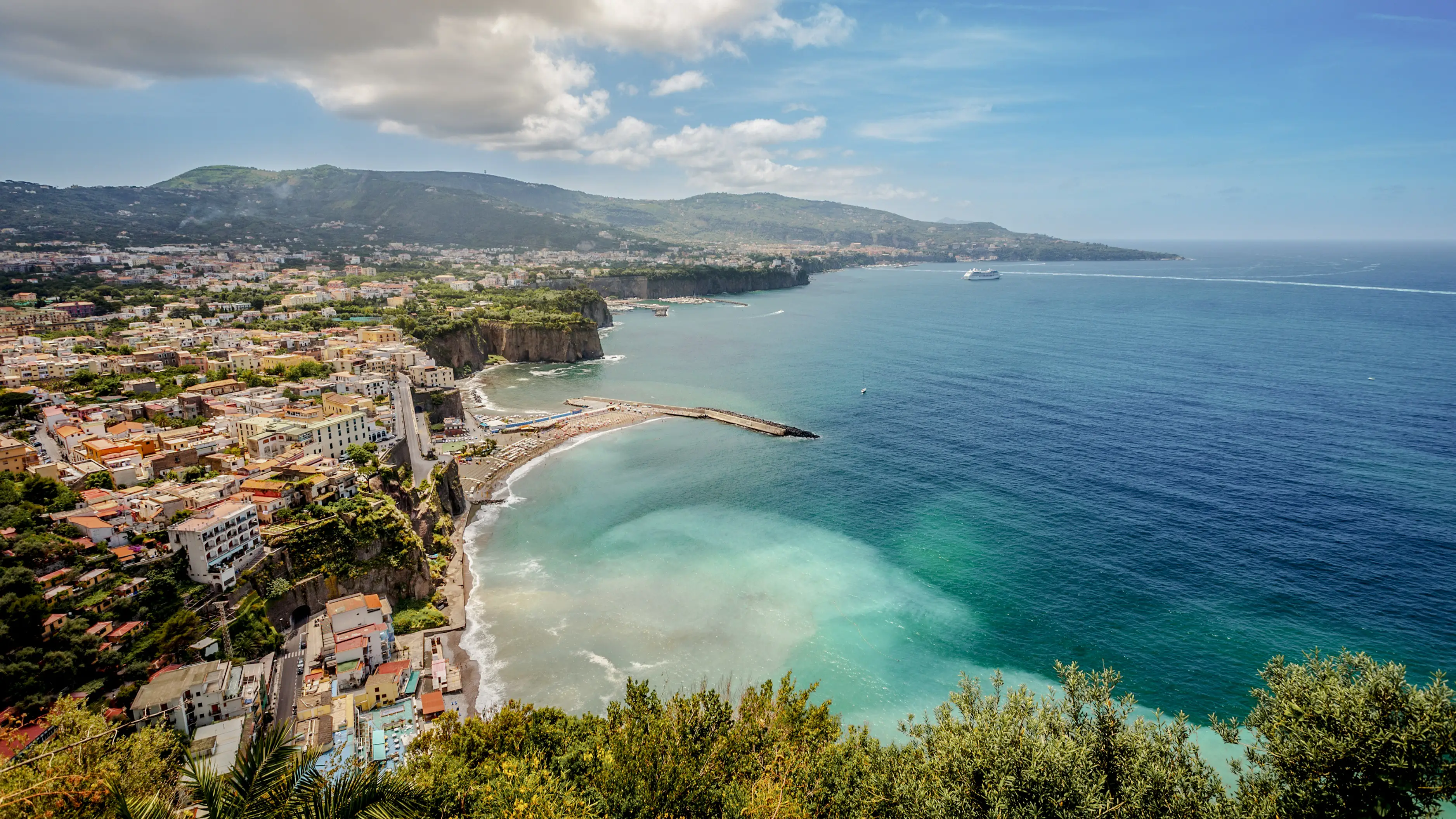 View of the Marina Piccola coastline off Sorrento with a view of the harbor and hilly landscape in the background
