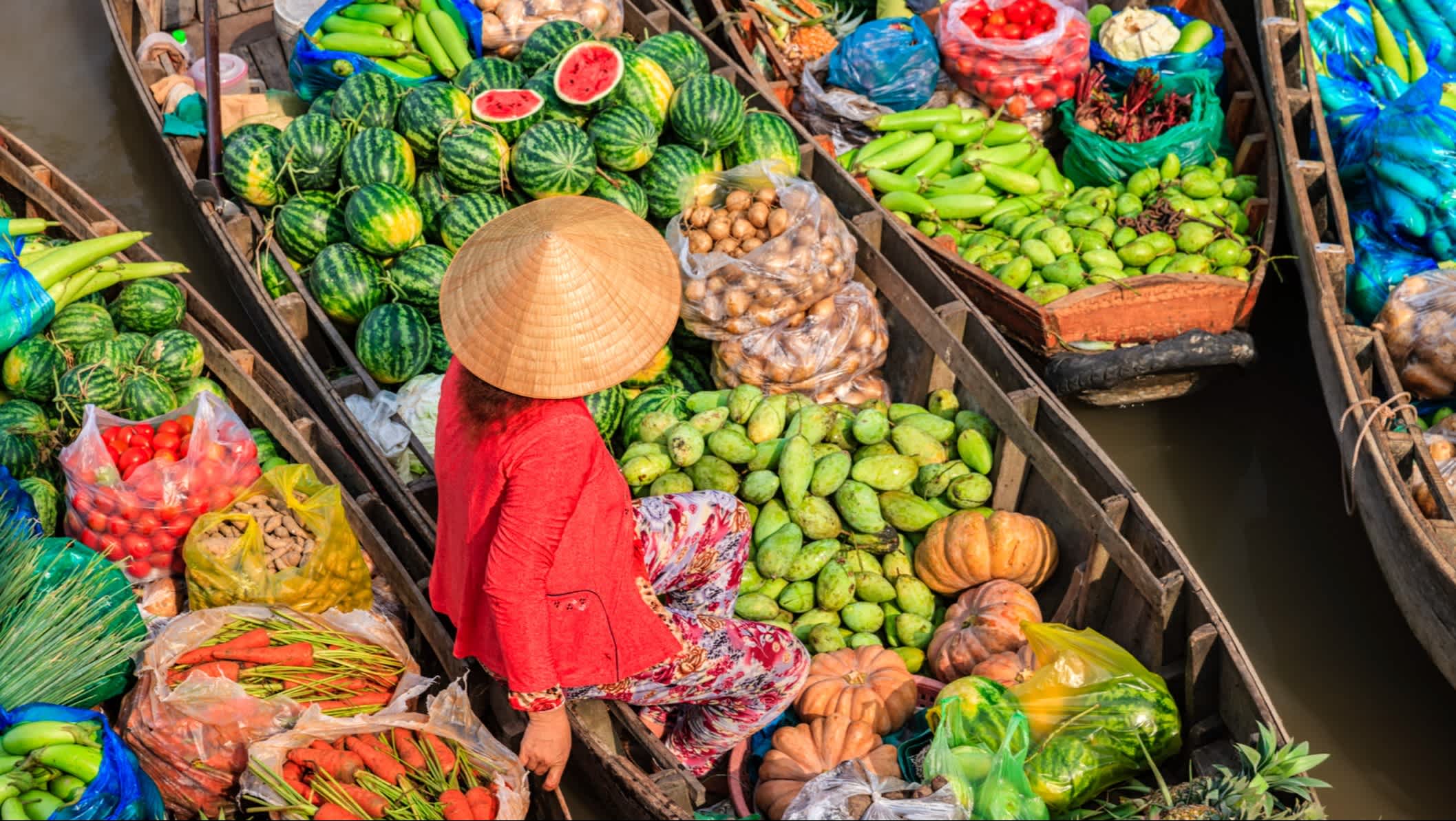 Vietnamesische Frau verkauft Früchte auf einem schwimmenden Markt im Mekong-Delta, Vietnam