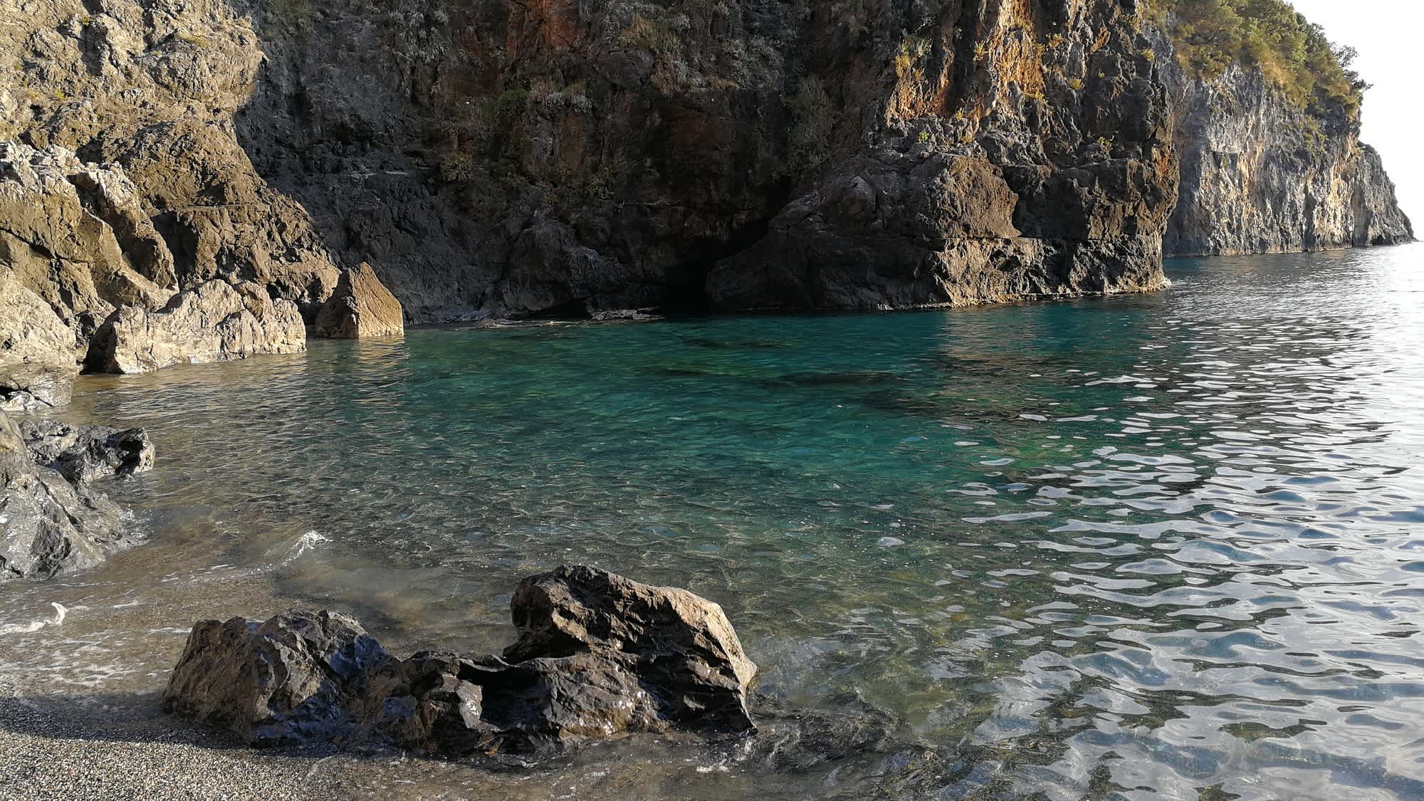 Vue sur une plage de galets et un paysage rocheux, sur la côte Amalfitaine, en Italie.