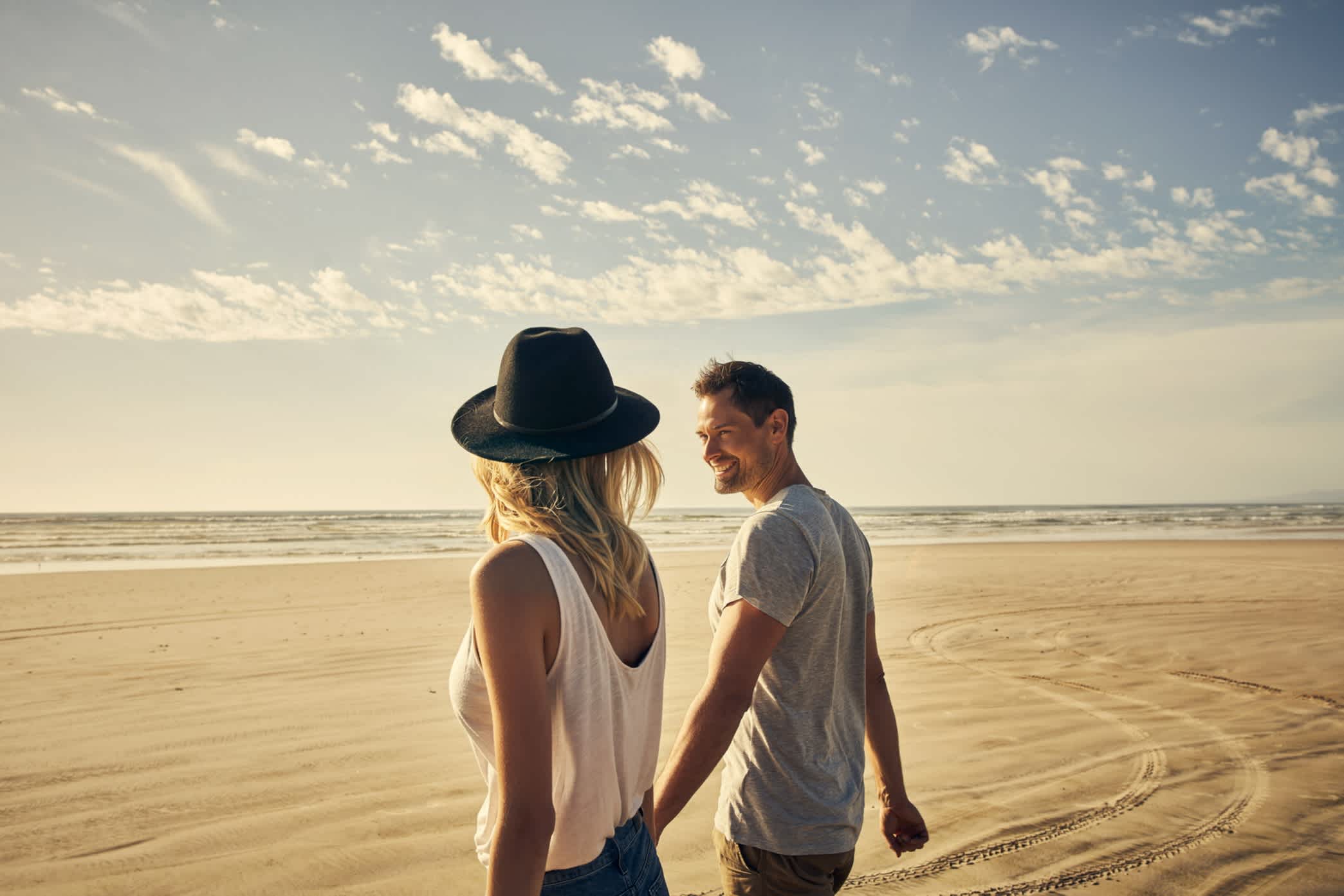 Junges Paar bei einem romantischen Spaziergang am Strand in Australien.