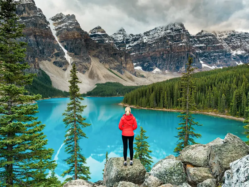 Canada, Alberta, parc national Banff, lac Une femme se tient devant un lac glaciaire turquoise dans le parc national Banff, Alberta, Canada.