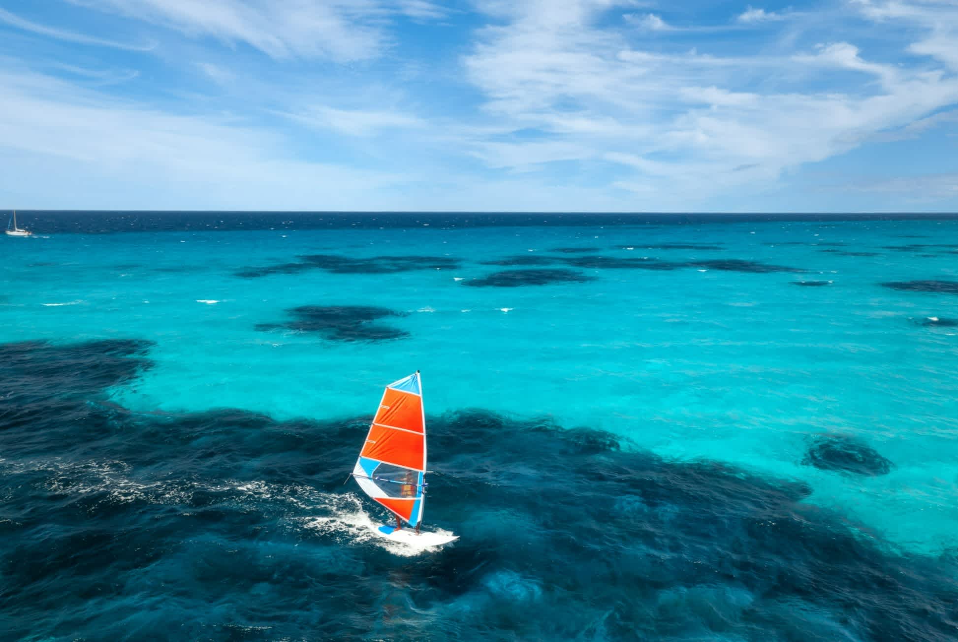 Luftaufnahme des Windsurfers auf blauem Meer in Sardinien, Italien. 