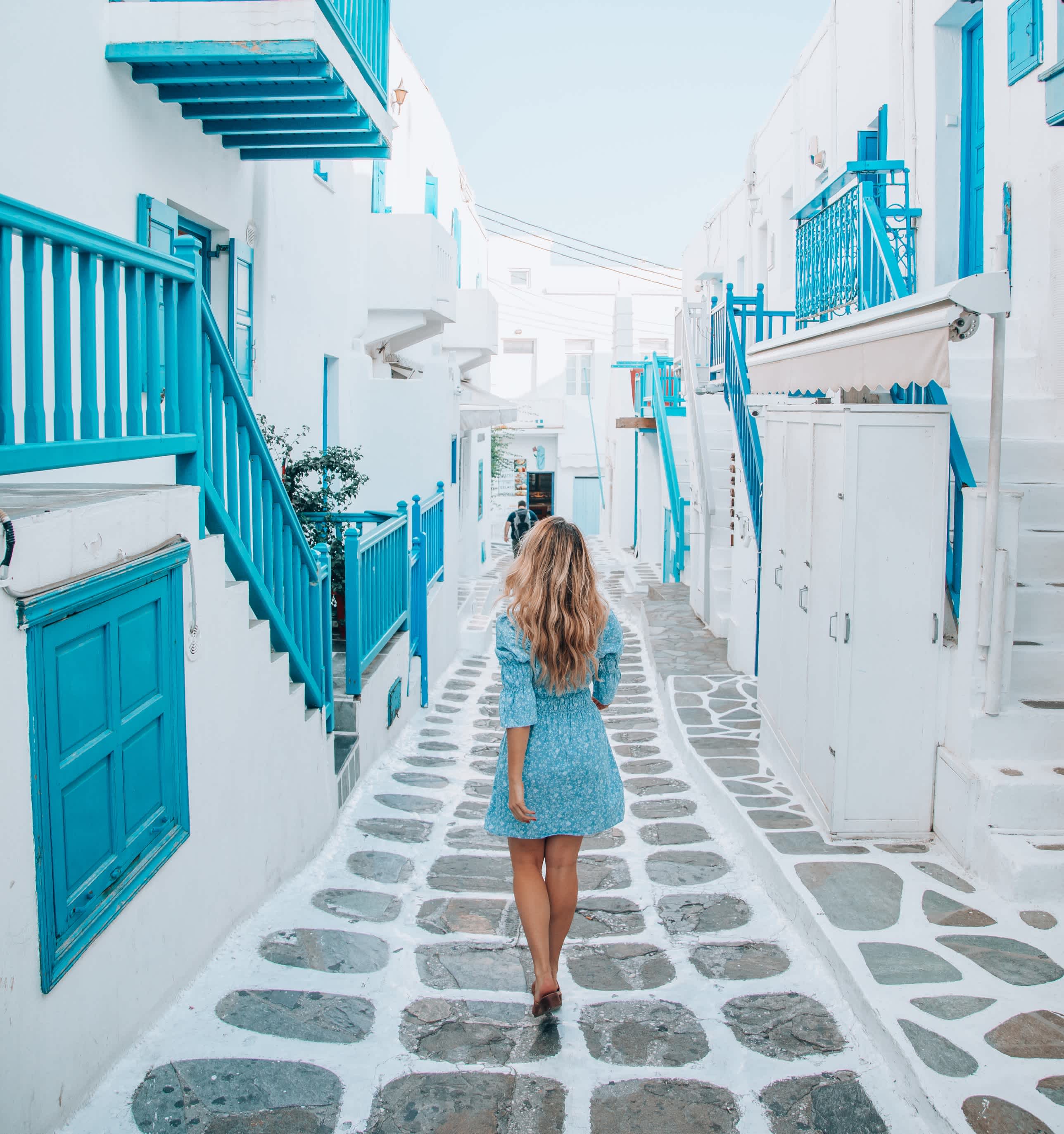 Junge Touristin geht durch die Straßen der Insel Mykonos, Kykladen, Griechenland