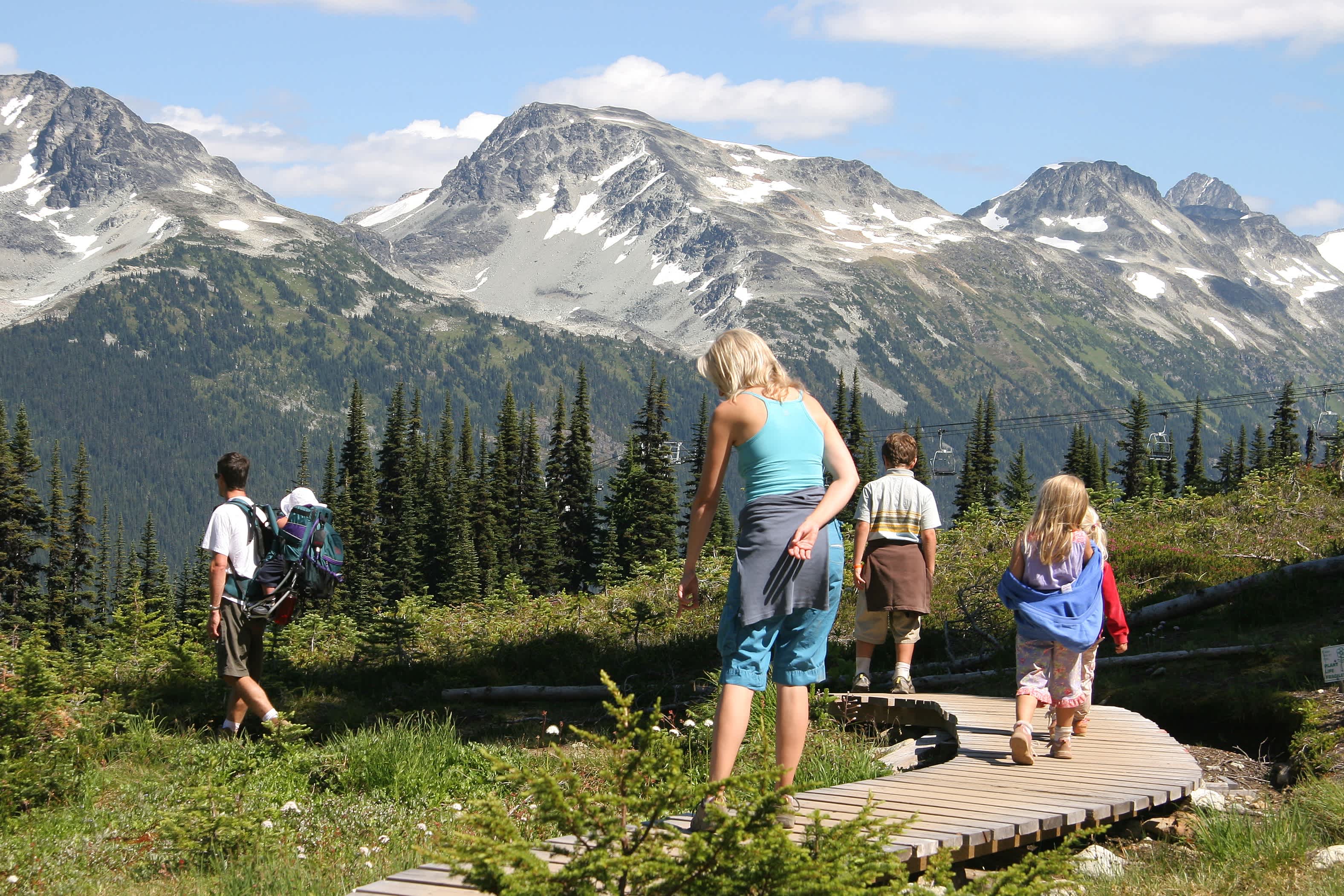 Familie beim Wandern entlang der Promenade mit Blick auf die Pflanzen und Berge in Alaska.
