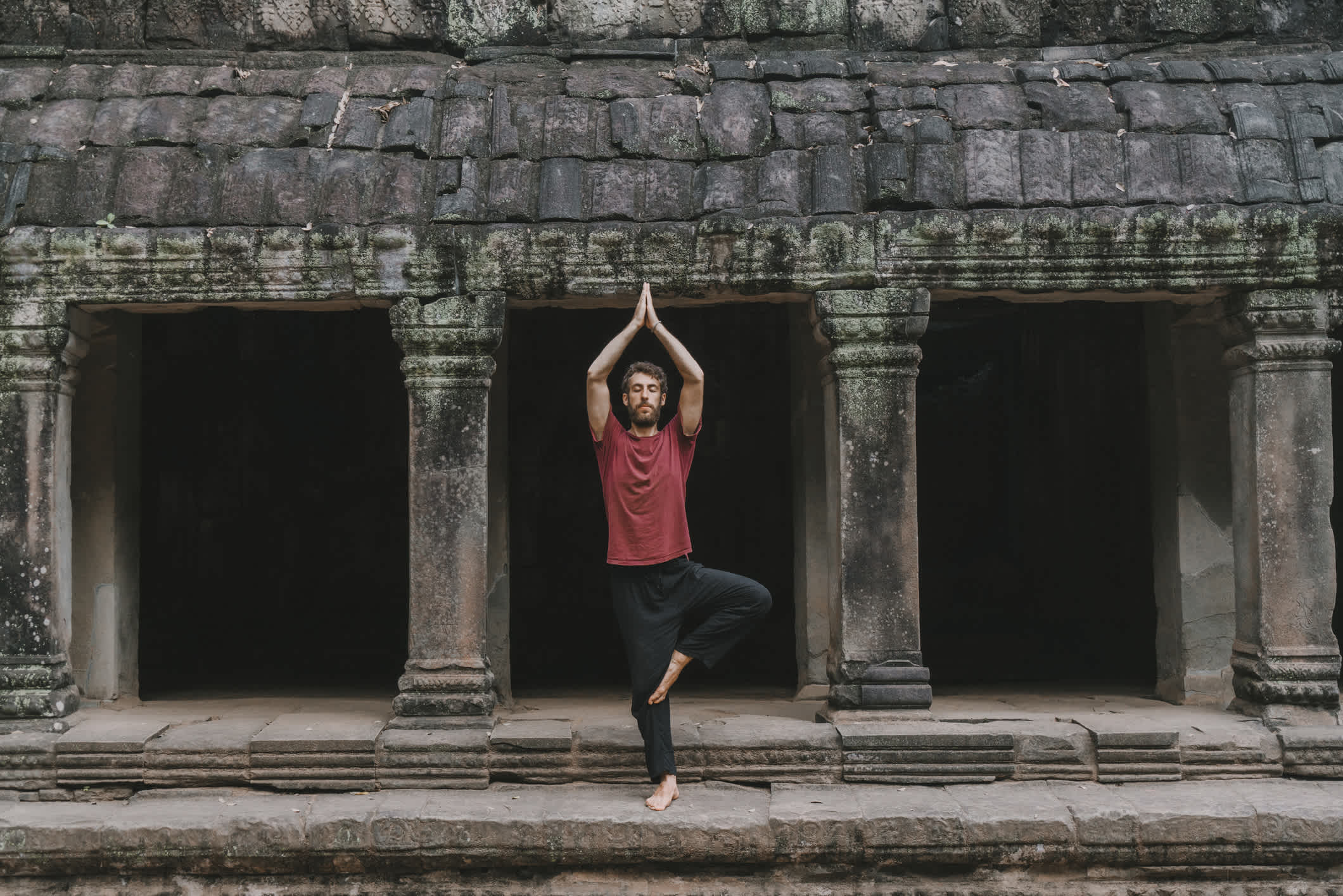 Cambodge, un homme fait du yoga dans le temple d'Angkor Wat.