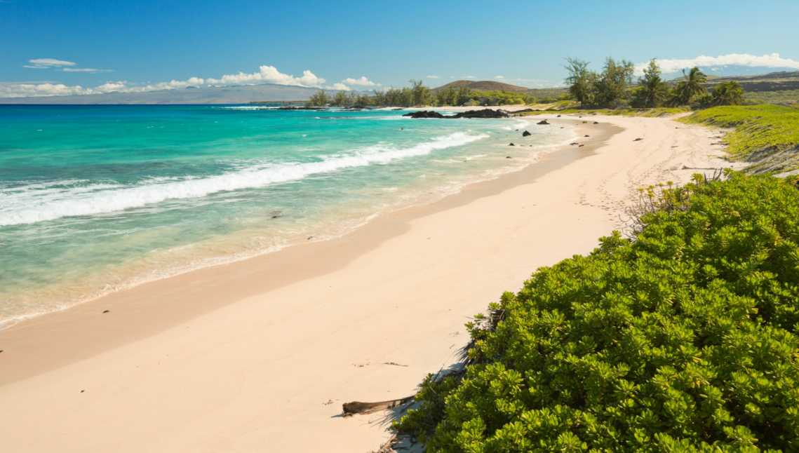 étendue de sable blanc au bord d'une eau turquoise sur la plage de Makalawena, Big Island à Hawaï 