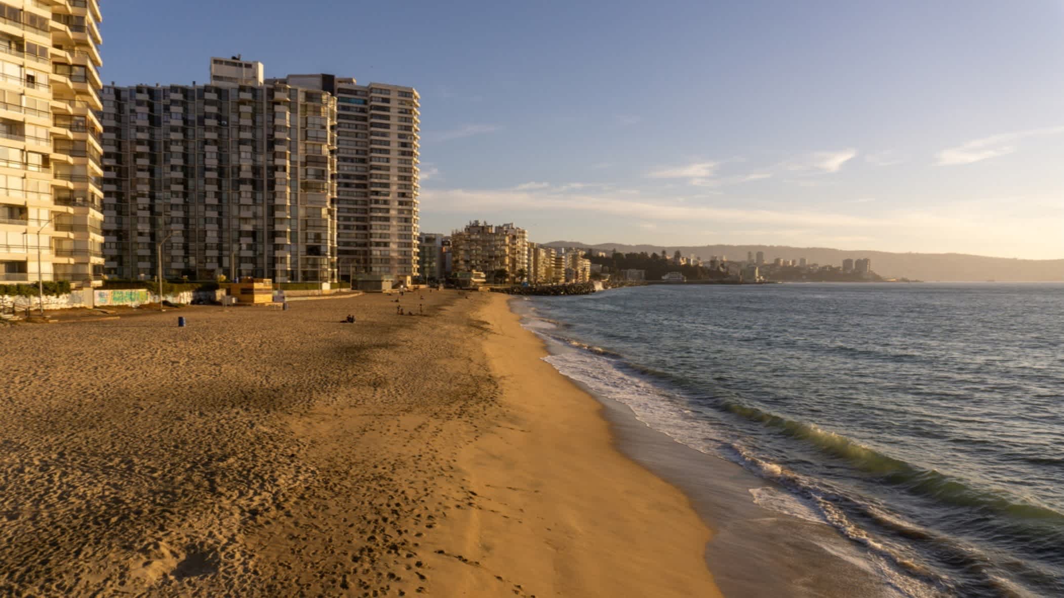 Bild vom Acapulco Strand nahe Vina del Mar in Chile mit Blick auf den goldenen Sand, das dunkle Meer sowie den Hochhäusern an der Promenade.