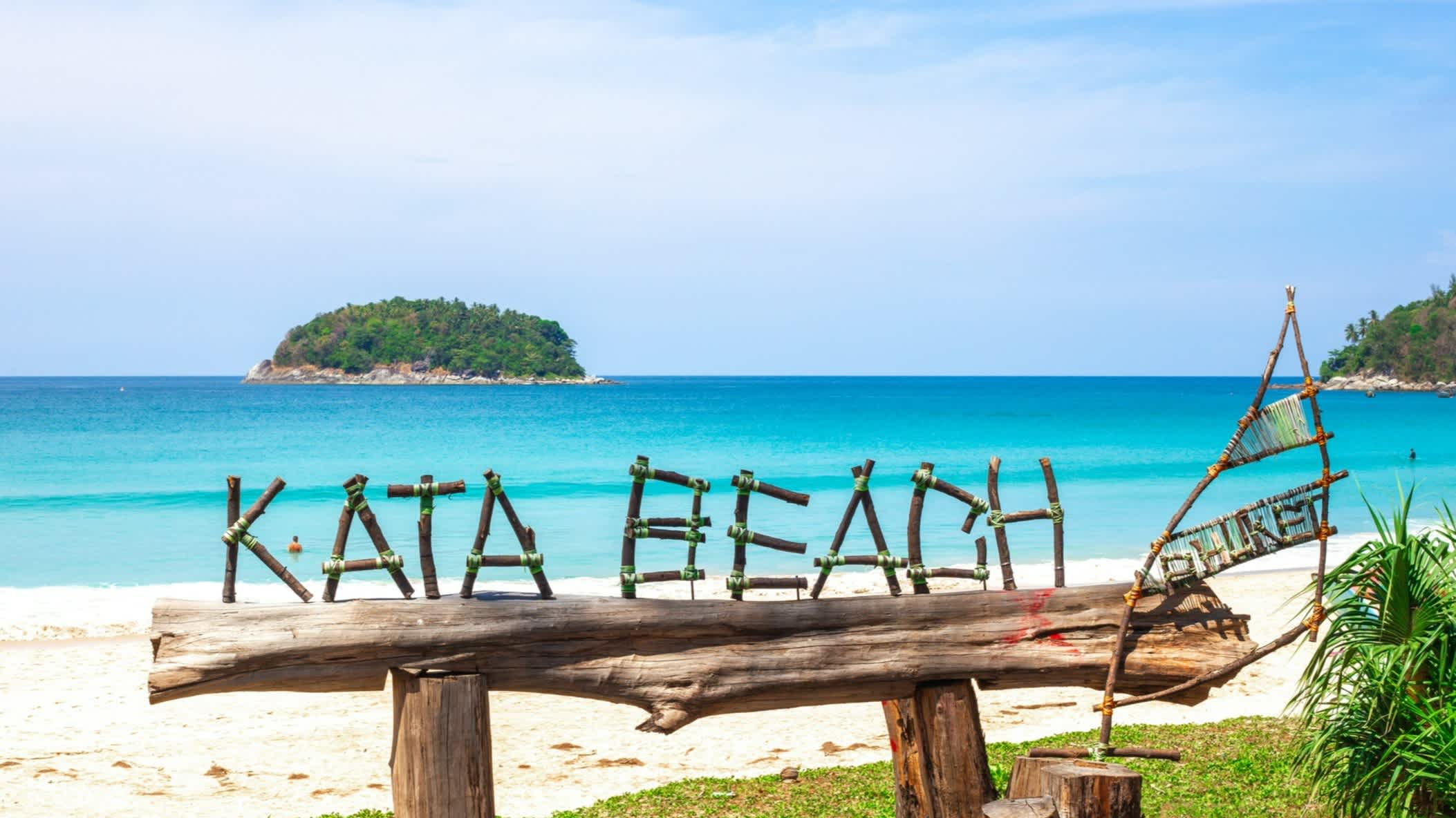 Panneau en bois et bambou indiquant le nom de la plage tropicale de Kata Beach en Thaïlande, sur l'île de Phuket avec du sable blanc et une eau turquoise en arrière plan