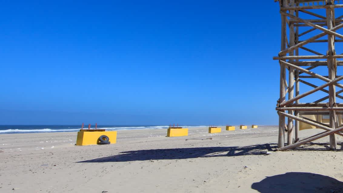 Ein verlassener Aussichtsturm an der einsamen Torra Bay in Namibia bei klarem Himmel.