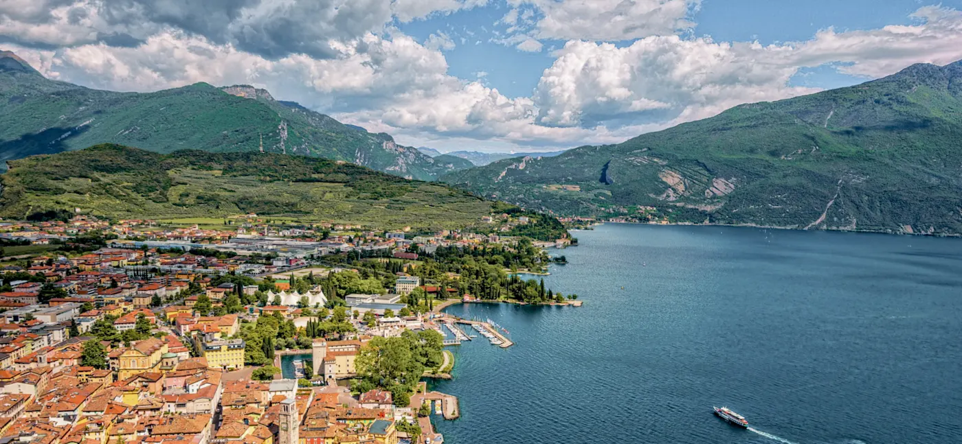 Italy, Trentino, Riva del Garda, City Town with red roofs and a view of a lake surrounded by mountains. Riva del Garda, Trentino, Italy