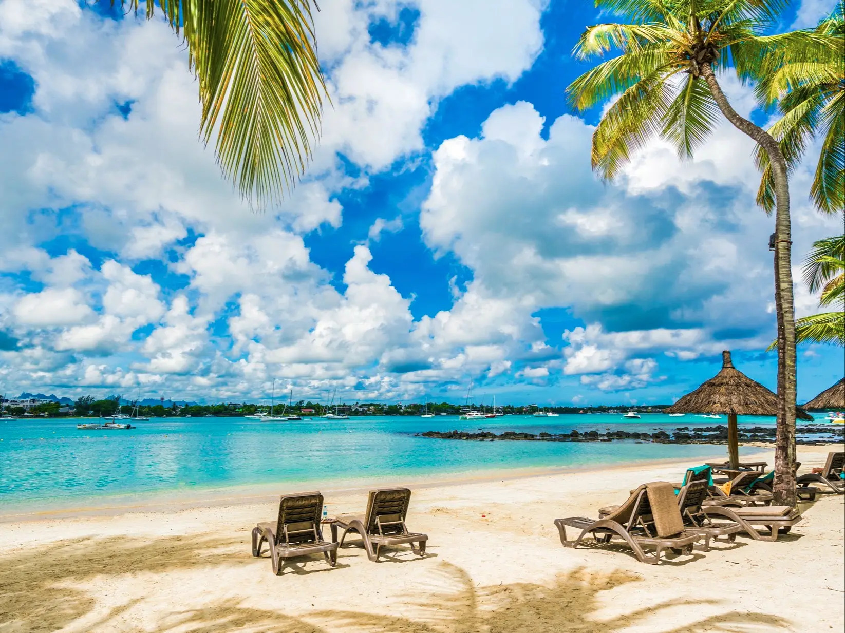 Une plage idyllique à l'île Maurice, avec deux chaises longues dans le sable, idéale pour se détendre et se relaxer en toute tranquillité.