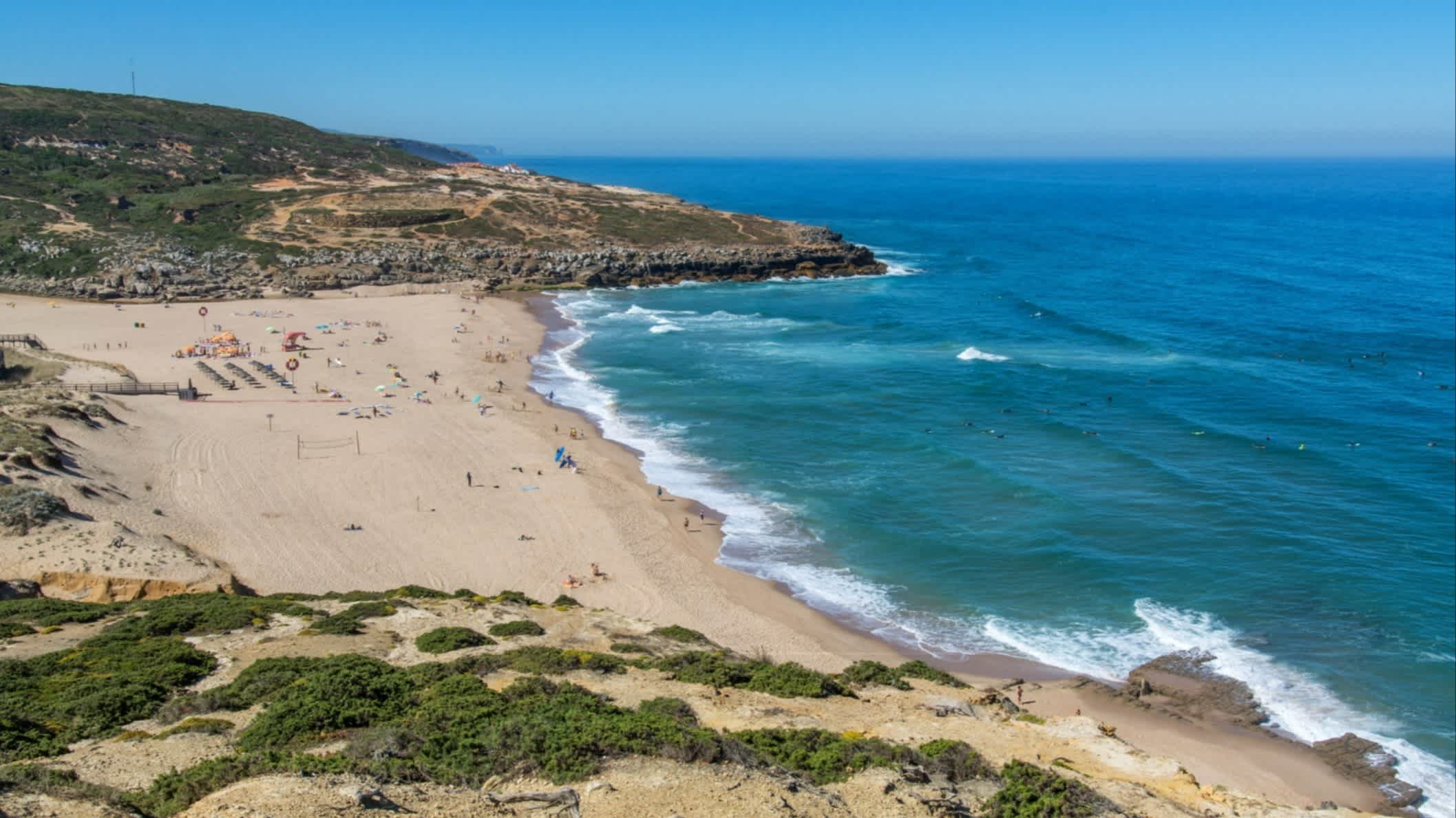 Eine Luftaufnahme von der Klippe auf den Strand Praia da Foz do Lizandro, Ericeira, Portugal bei Sonnenschein.