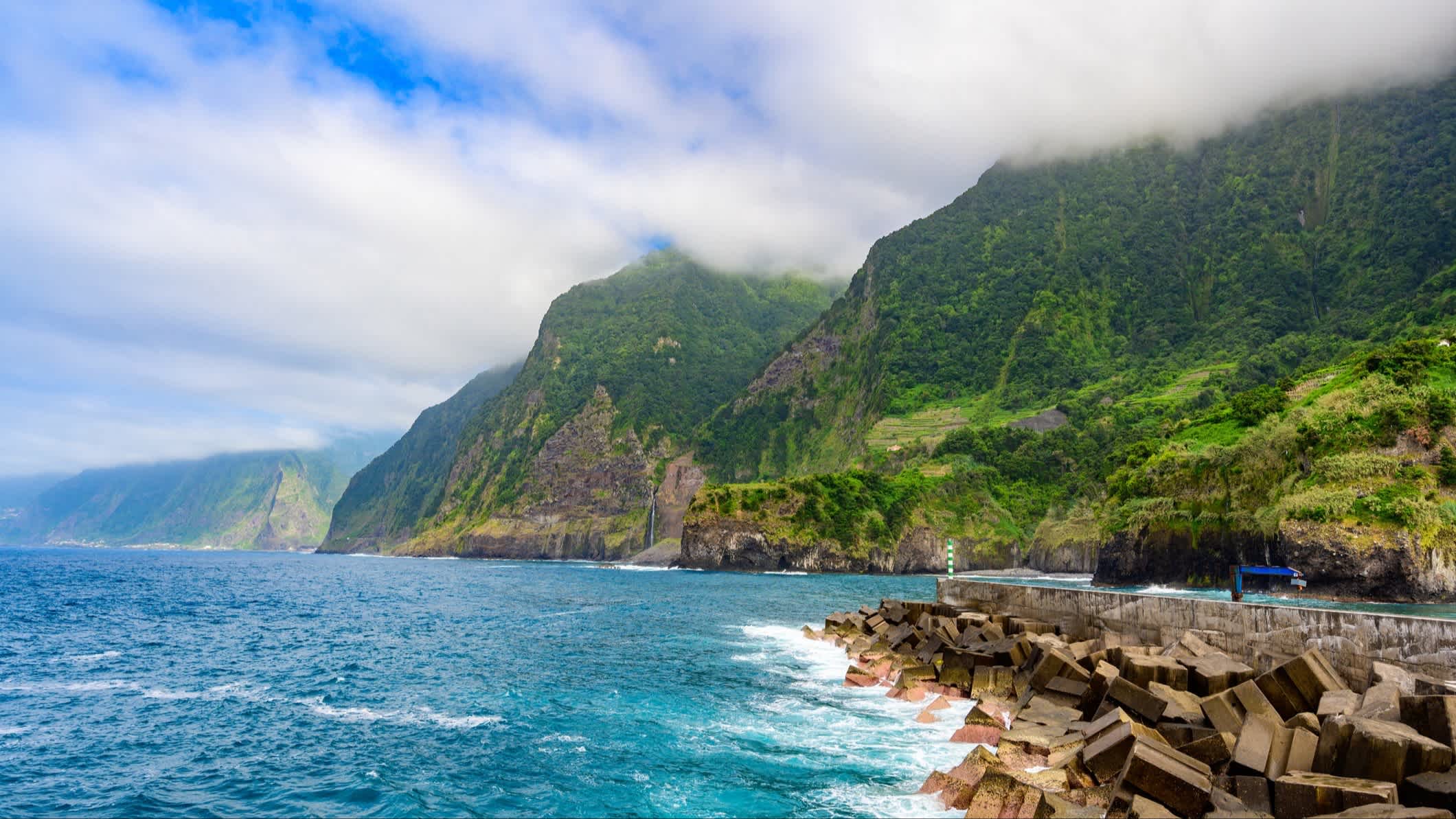 Die Küstenlandschaft mit Bridal Veil Falls, Porto Moniz, Seixal, Madeira, Portugal mit Nebel in den Bergen.