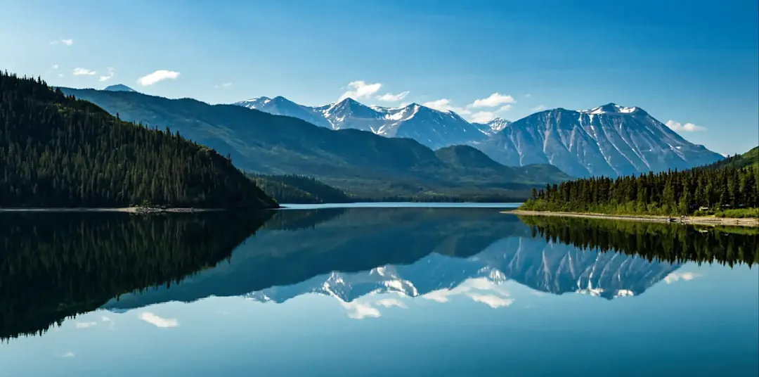 See mit Bergspiegelung und bewaldeten Ufern. Skagway, Alaska, USA