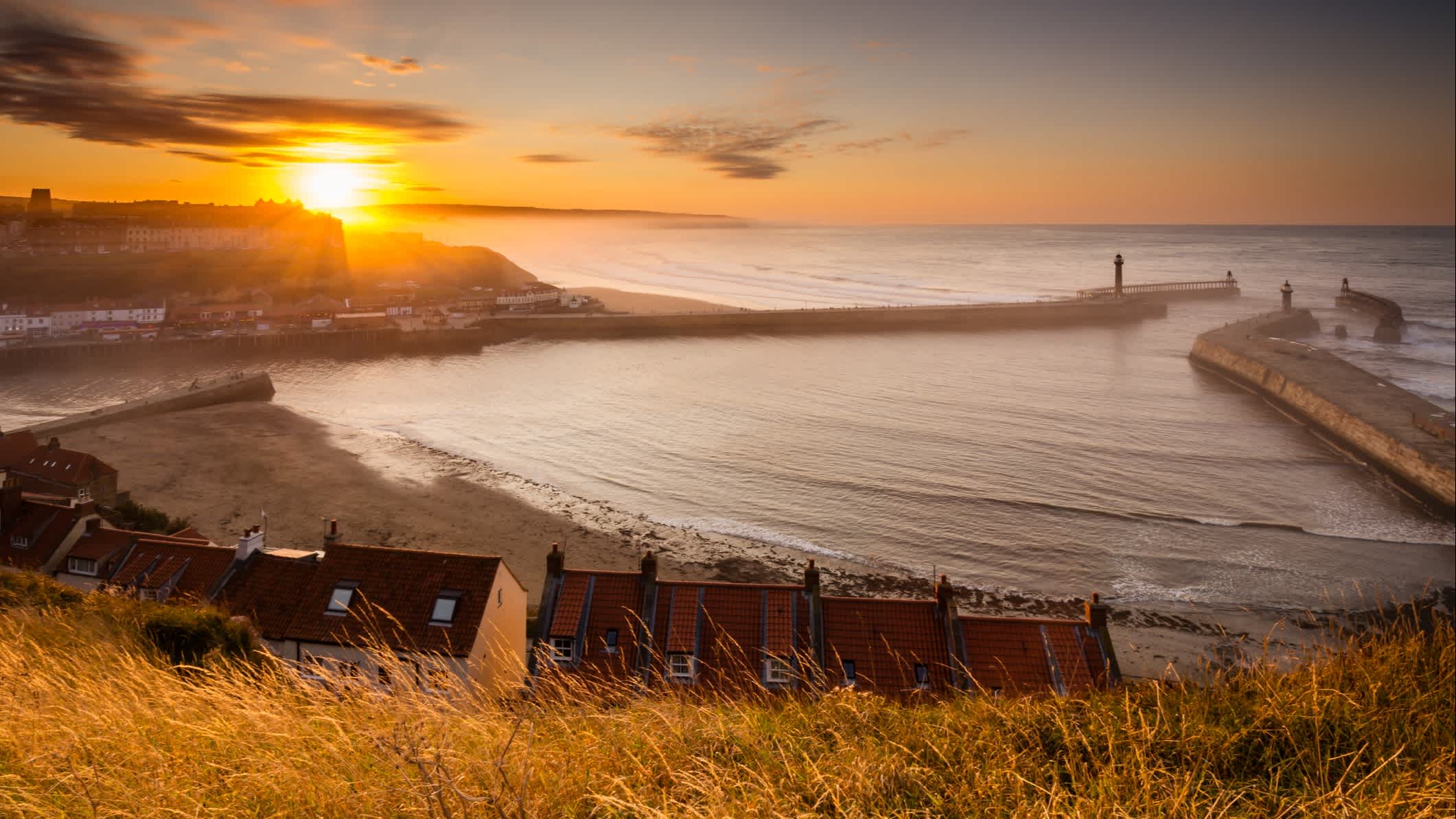 Der Hafen von Whitby in England bei Sonnenuntergang, der durch den von den Klippen von Sandsend