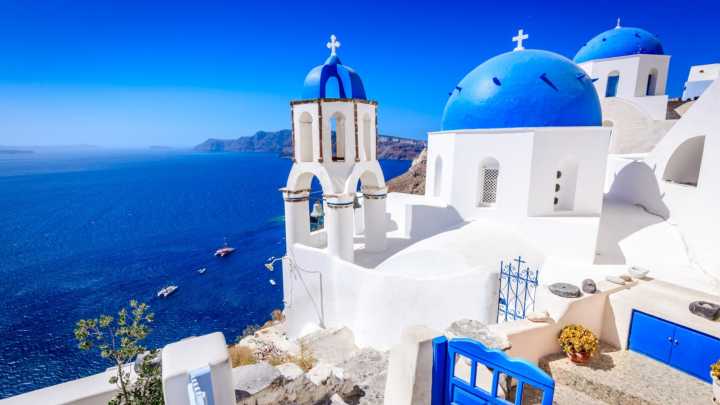 Village de Oia au nord de l'île de Santorin en Grèce connue pour ses maisons et églises blanches aux toits bleus.