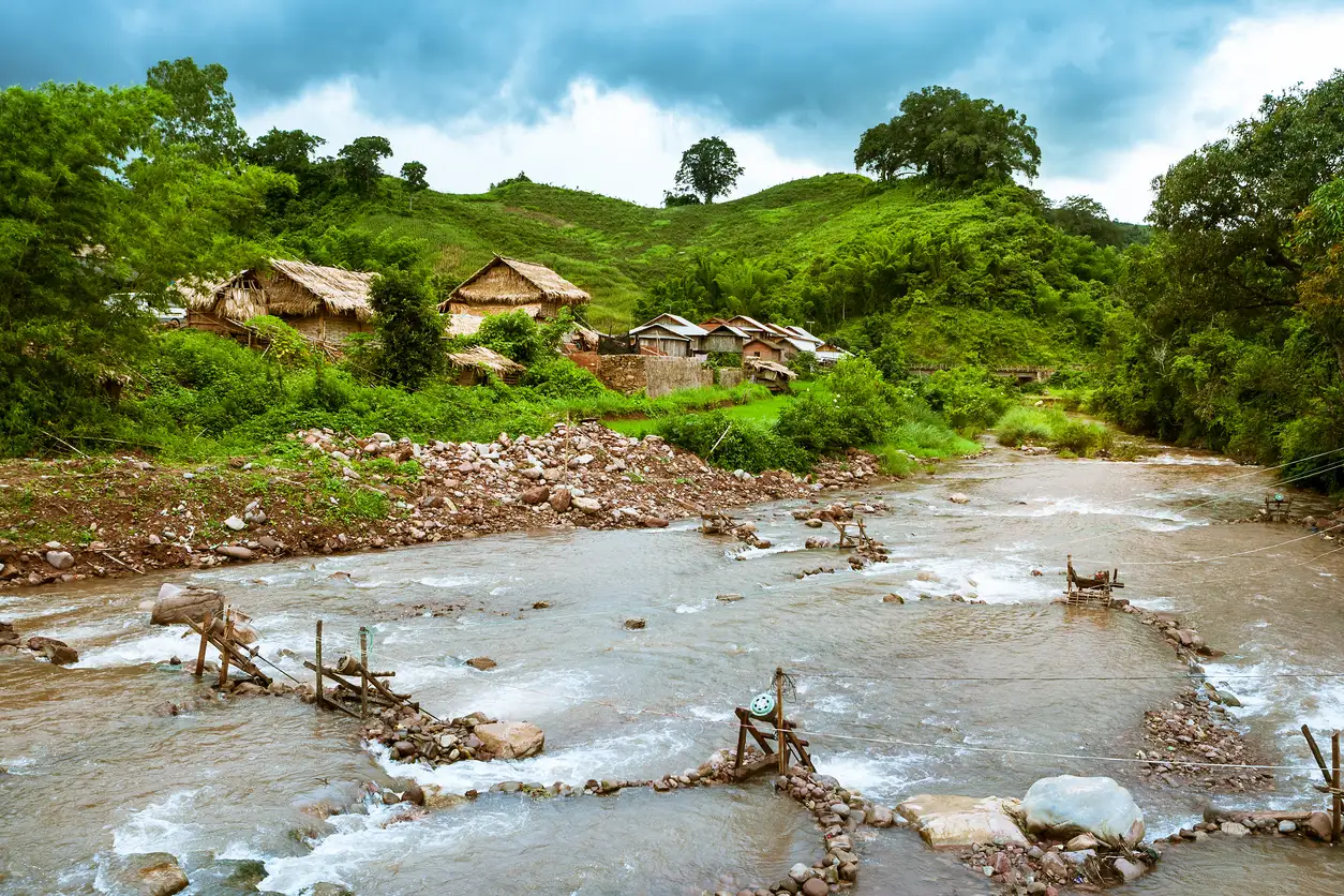 Laos, Provinz Phongsali, Bergdorf Bergdorf mit Holzhütten an einem Fluss umgeben von üppiger Vegetation