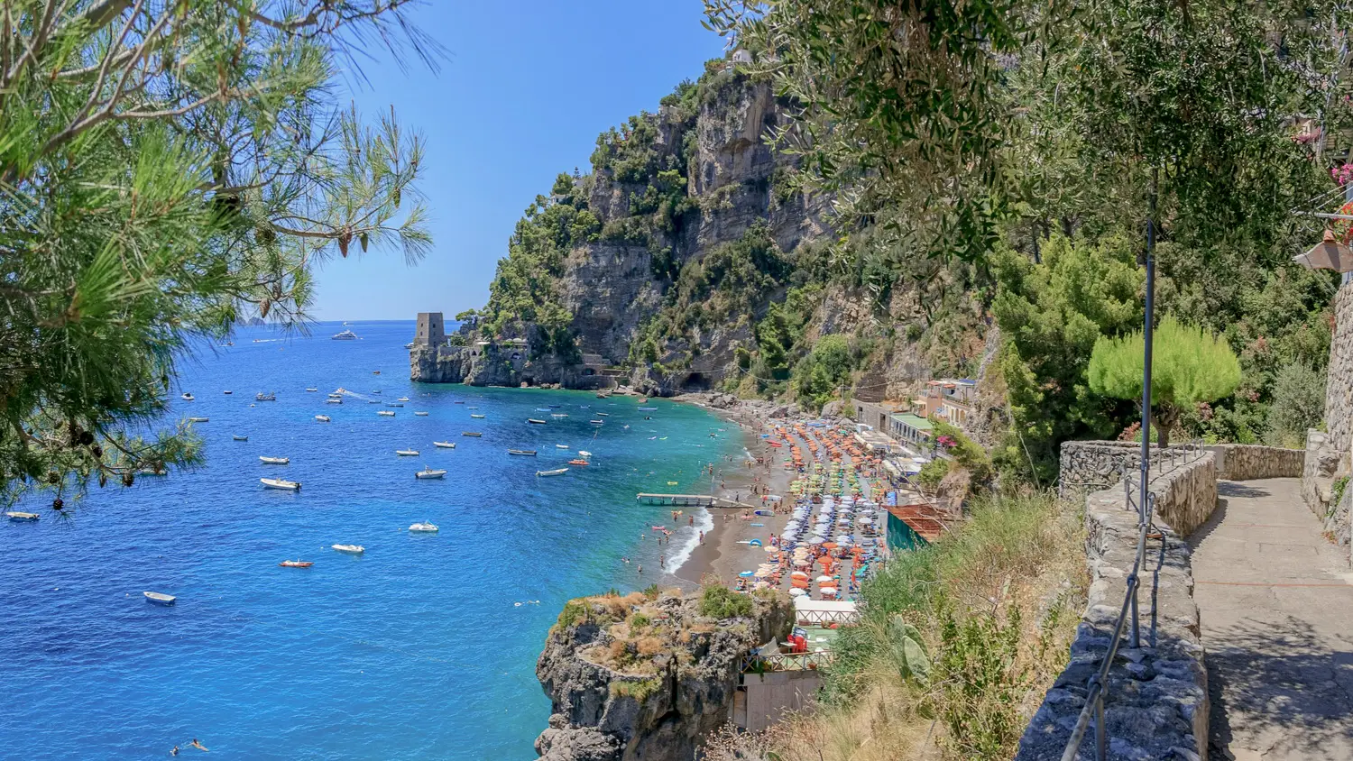 Aerial view of the small bathing bay of Fornillo with the mountain in the background and the deep blue sea