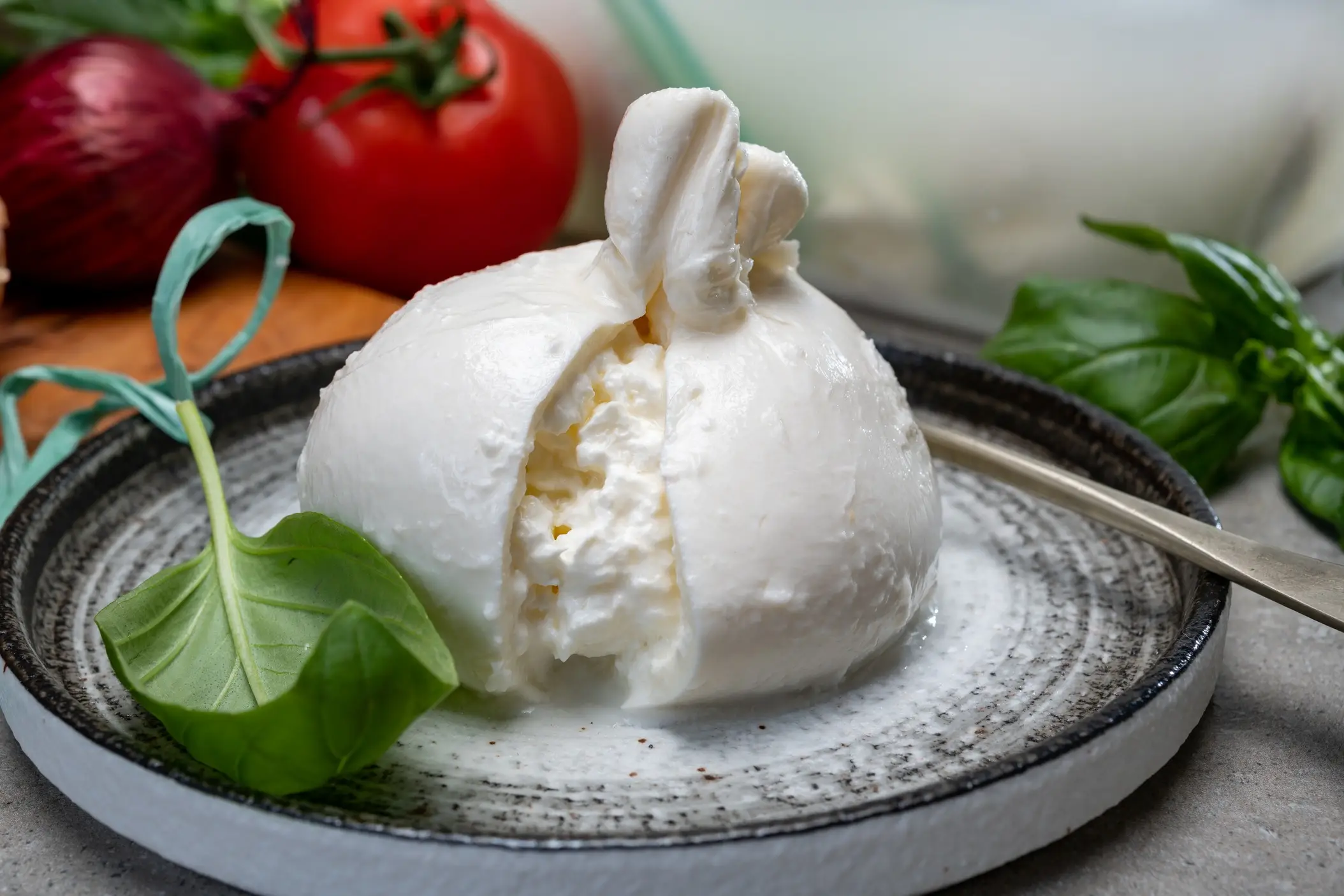 Italien, Essen, Burrata Essen von frischem handgemachtem italienischem Weichkäse aus Apulien, weißen Bällchen aus Burrata oder Burratina-Käse aus Mozzarella und Sahnefüllung hautnah