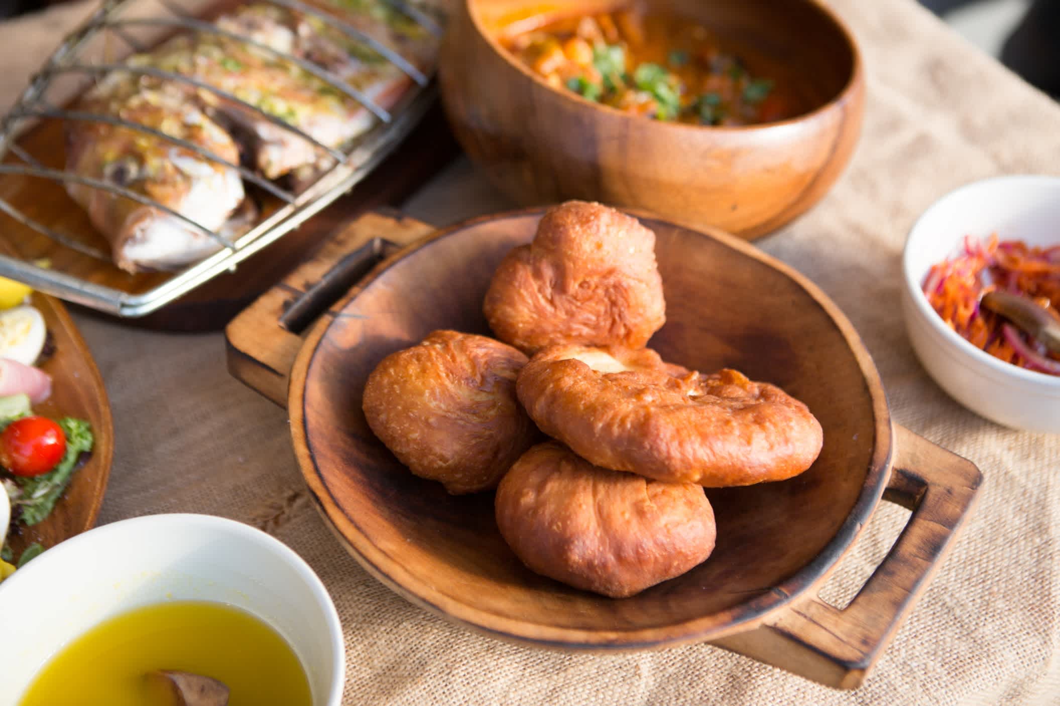 'Vetkoek' ist ein frittiertes Teigbrot, das einem Donut sehr ähnlich ist. Dieses Gericht ist in Südafrika beliebt und wird mit süßen oder herzhaften Füllungen verzehrt.