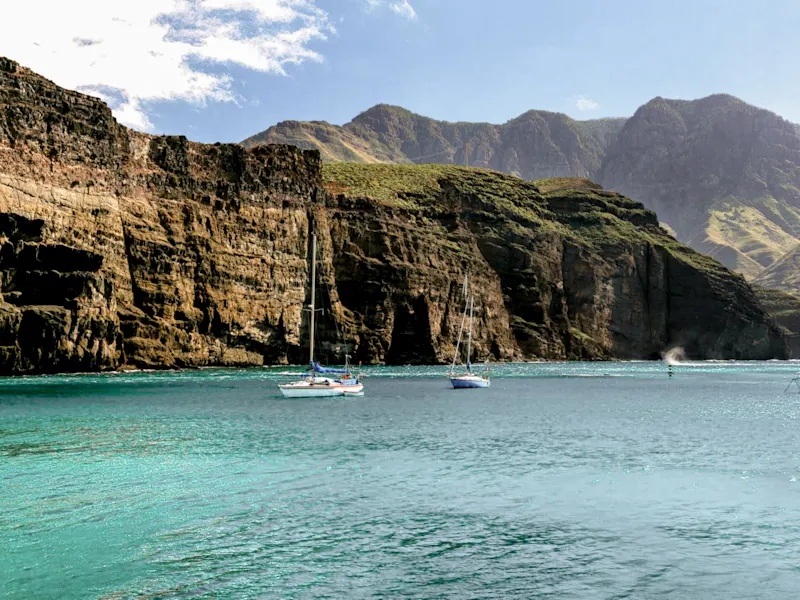 Spanien, Gran Canaria, Los Gigantes Segelboote vor hohen Klippen und blauem Wasser. Los Gigantes, Gran Canaria, Spanien.