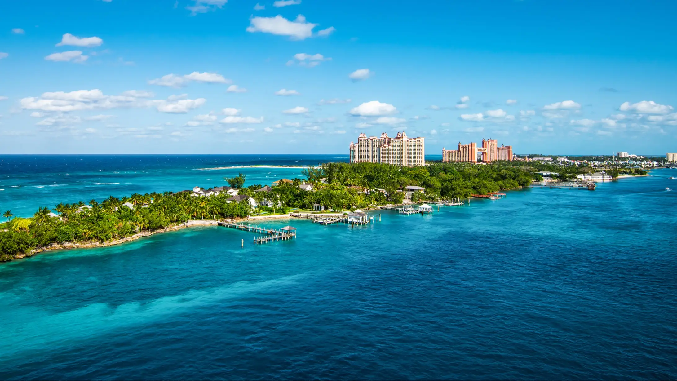 Helles und lebendiges Panoramabild mit Paradise Island und Palmen in der Nähe des Kreuzfahrthafens von Nassau auf den Bahamas. Blauer Himmel und einige weiße Wolken. Breites Bild.

